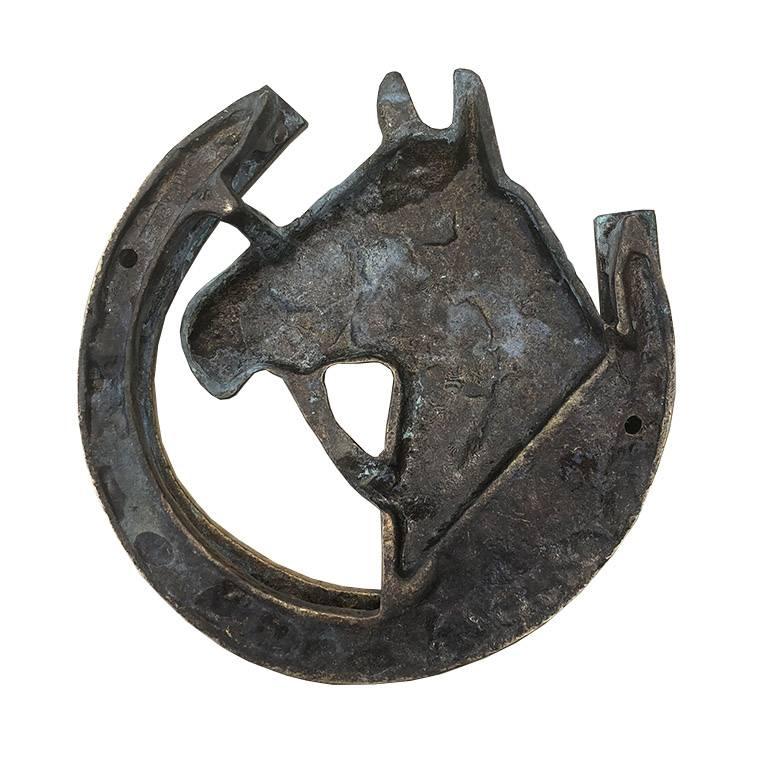 Brass horse door knocker. In wonderful condition. Lifts up to reveal a patterned underside. Two places for screws to affix to a door.