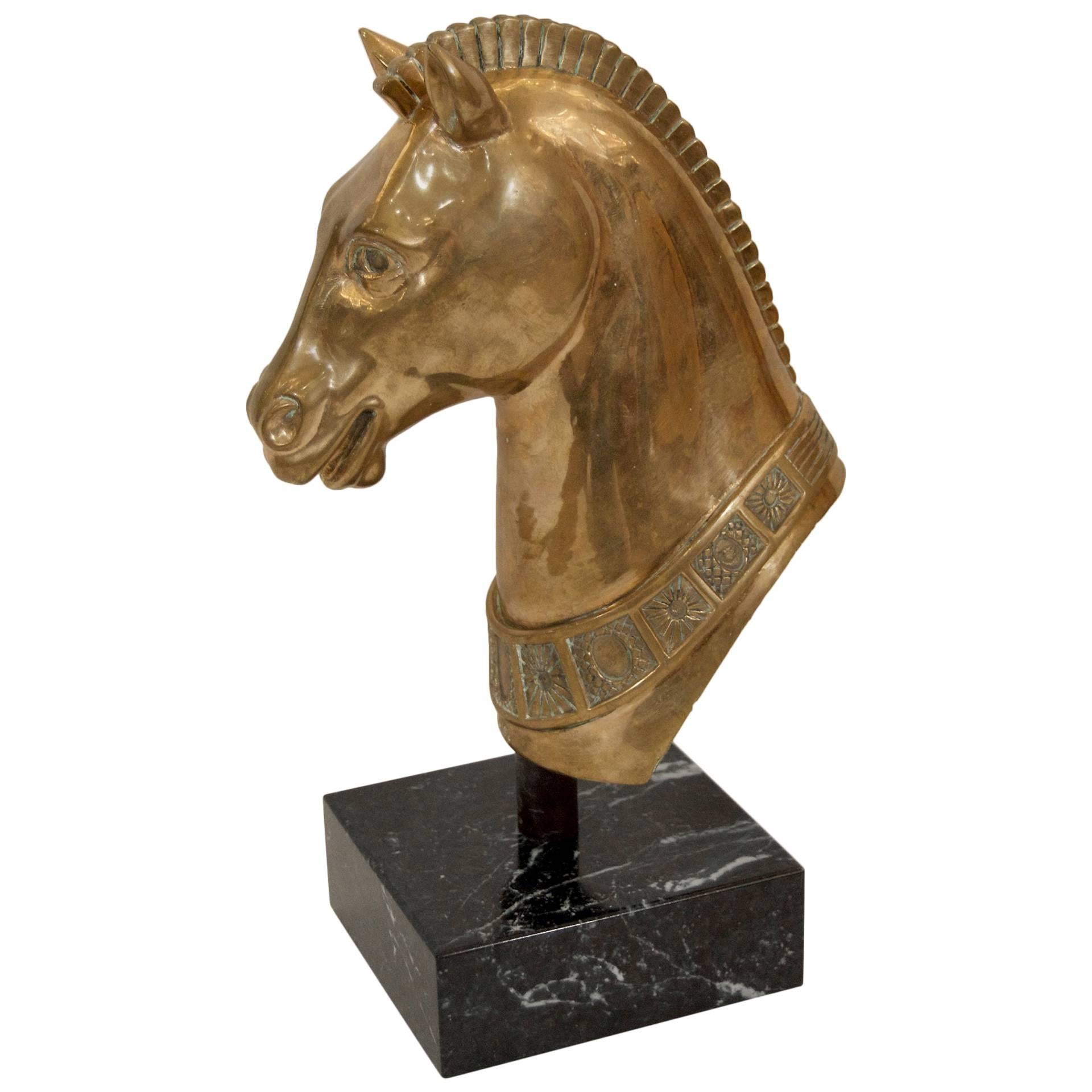 Scultura in ottone massiccio ben dettagliata di una testa di cavallo su una base di marmo.

