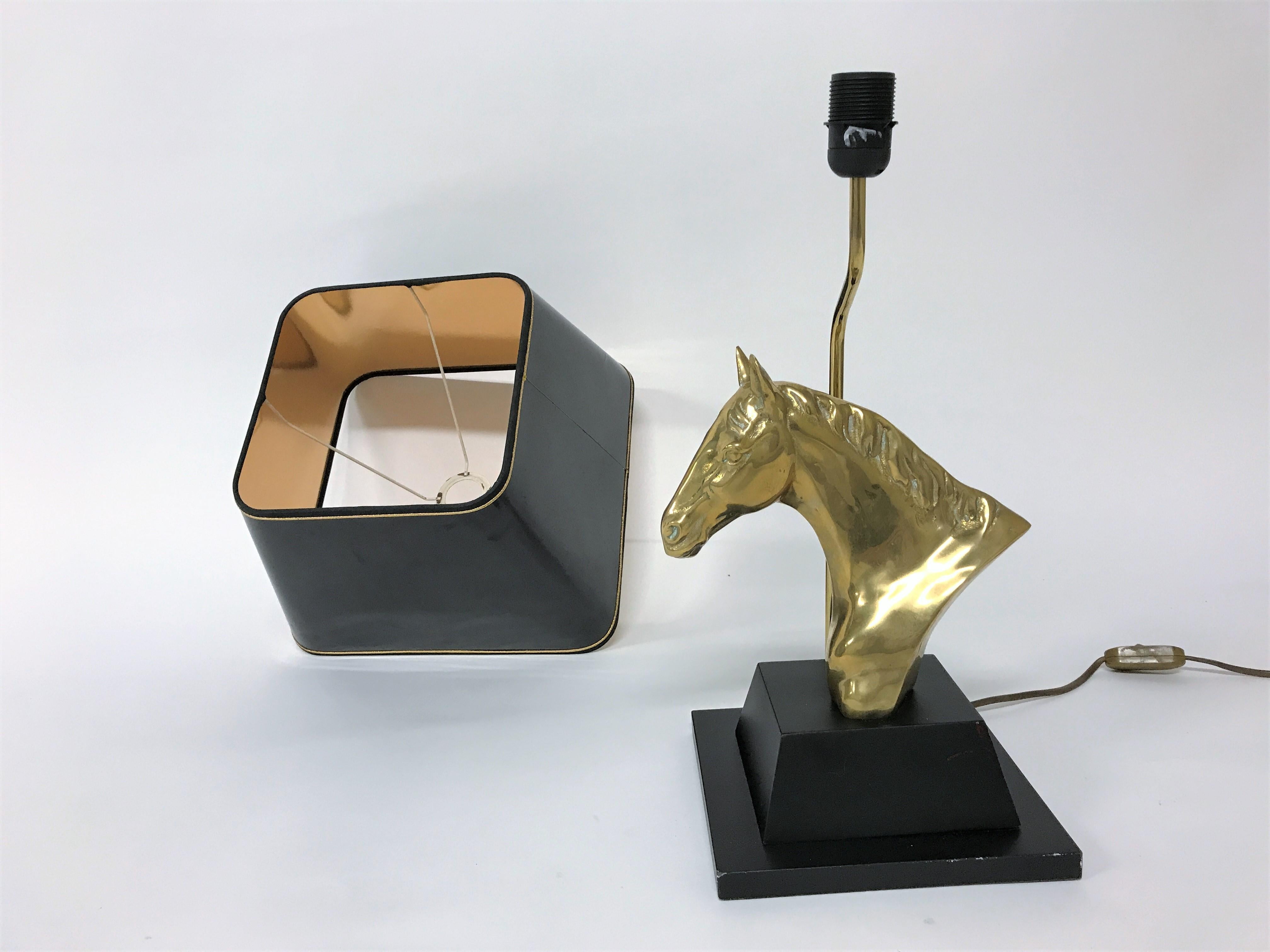 Brass horse head table lamp in the style of Maison Jansen.

The brass horse head is mounted on a lacquered wooden base and finished with a period black and gold shade.

Stylish table lamp with a luxurious appeal.

The height of the lamp shade