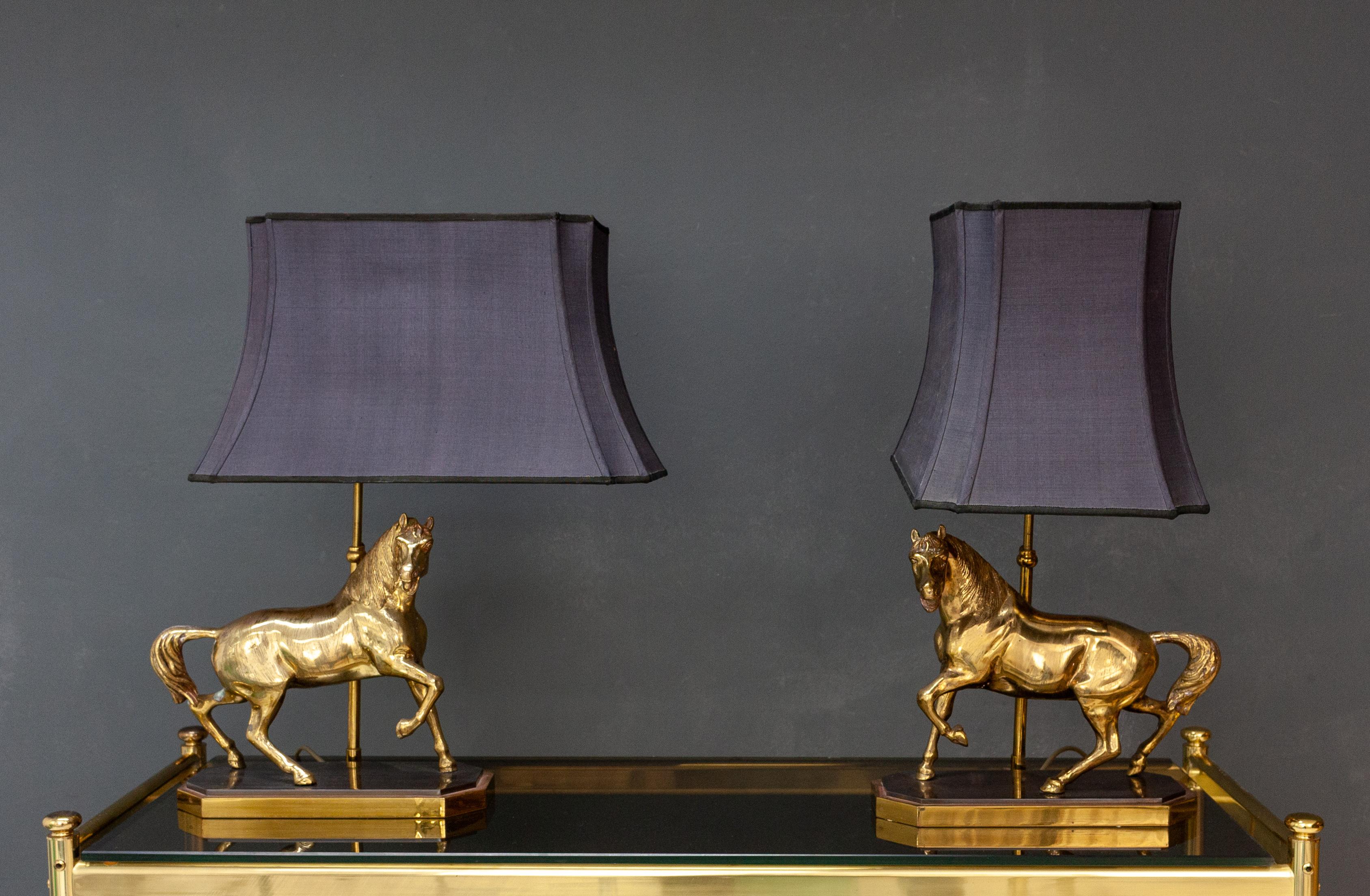 Love this superb set of table lamps. Brass horses on a bronze base. Very nicely made. With real movement in the horses. Two light points a piece.
In the manor of Maison Jansen ore Deknud Original dark Purple shades with gold interior.
The shades