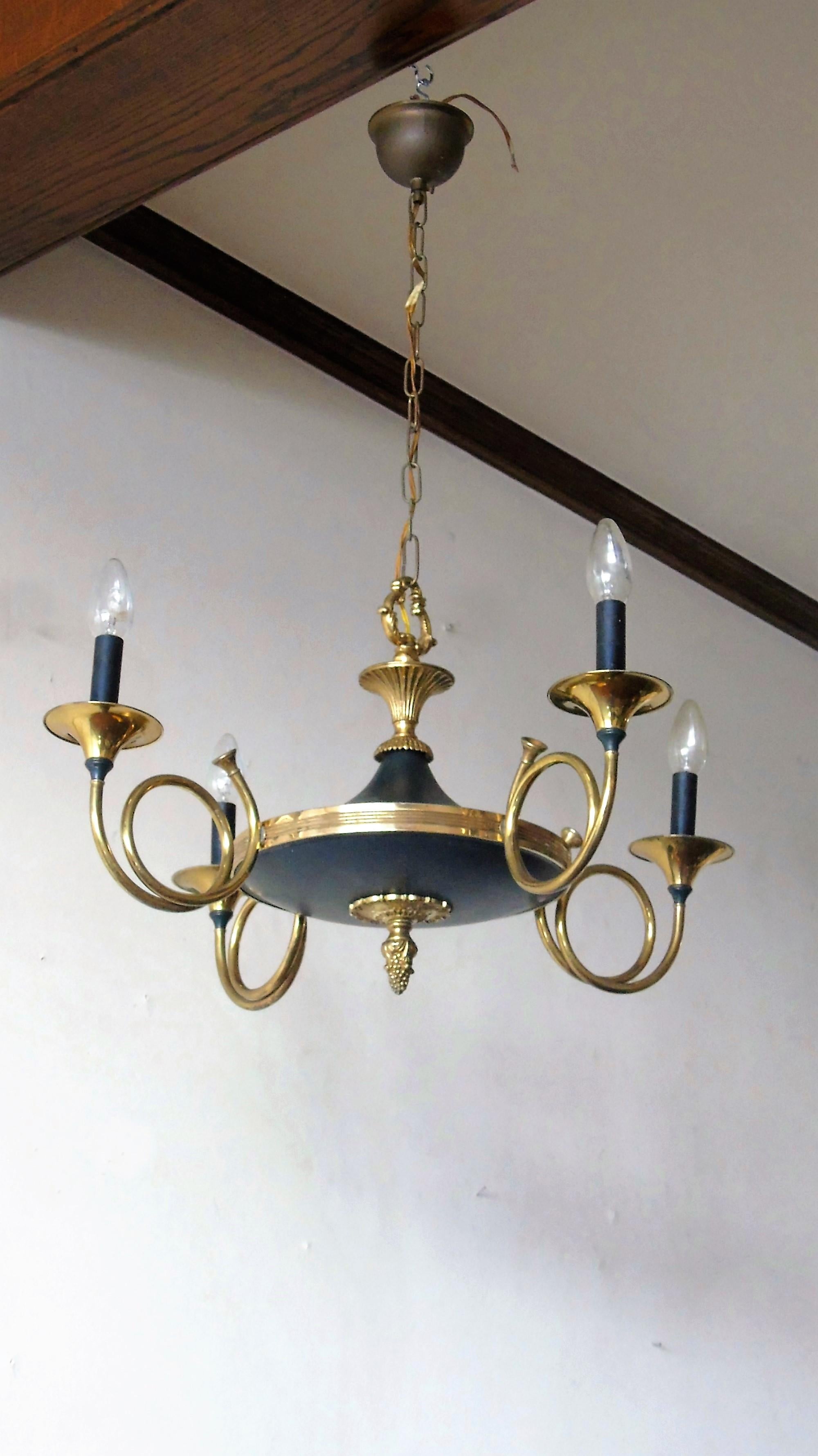 Brass four arm 'hunting horn' shaped chandelier made by Maison Baguès with an ormolu finial.

This classical chandelier is in a good, slight patinated condition.

Fully working light fixture with four regular E14 light sockets.

1940s,