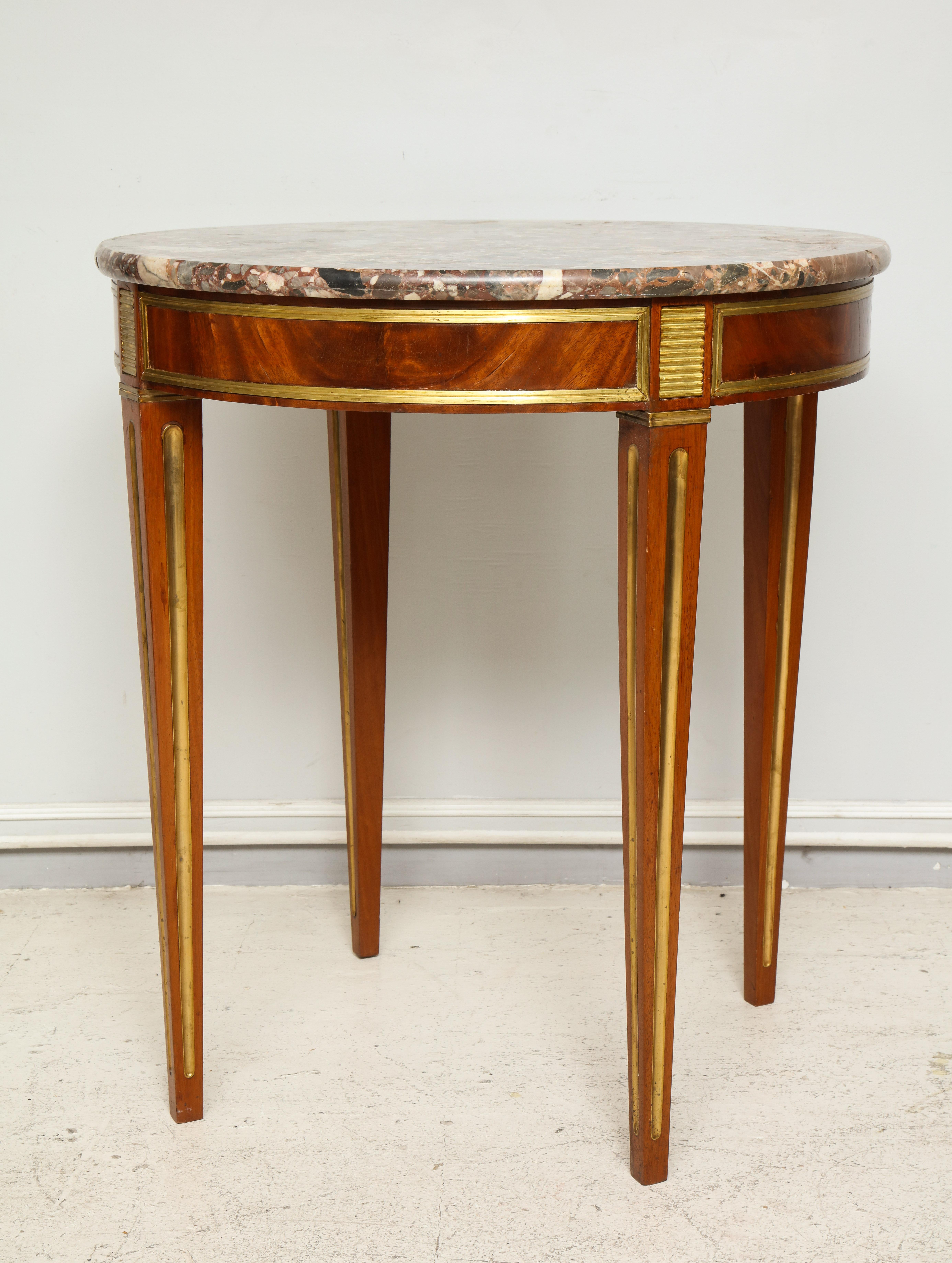Brass inlaid marble-top table in the neoclassic manner.