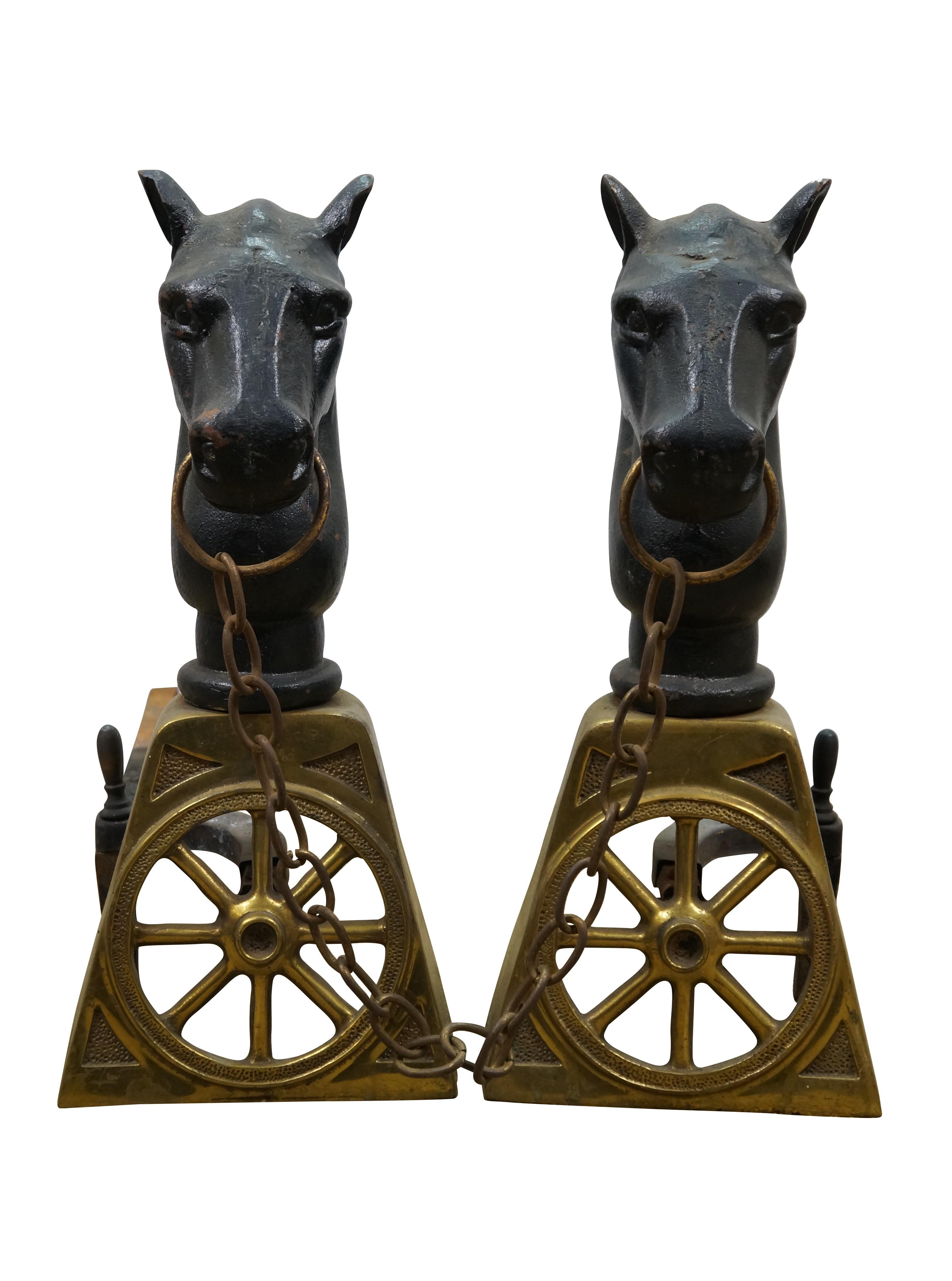 Coppia di androni per caminetto d'epoca, con basi in ottone fuso a forma di ruote di carro, sormontate da teste di cavallo in ferro e collegate tra loro da una catena con morsetto in ottone.  Ranch, Fattoria, Scuderia.

Dimensioni:
19