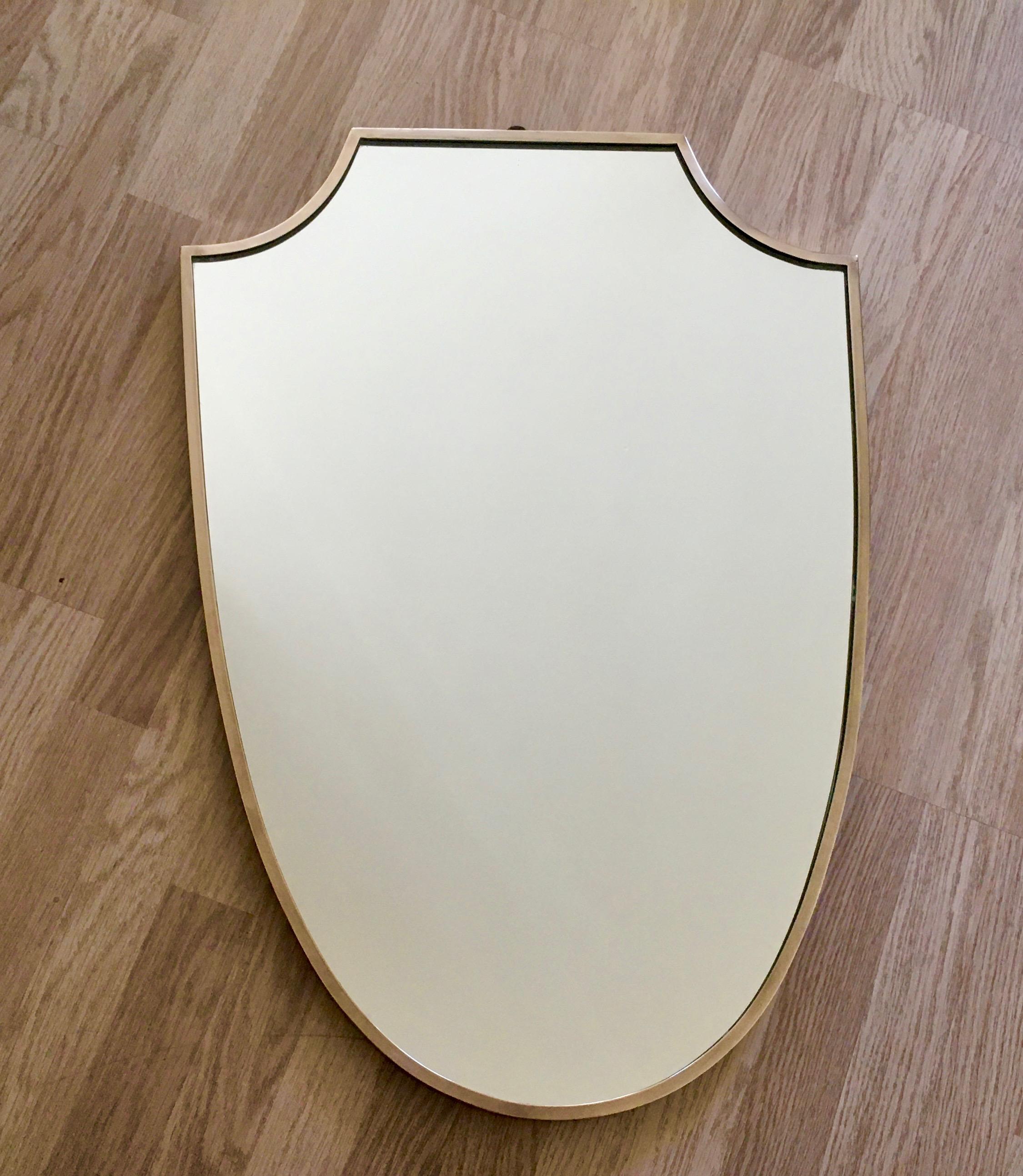 Brass shield-shaped wall mirror on a wood base.
Attributed to Gio Ponti.
Unsigned.
Italy 1950.
