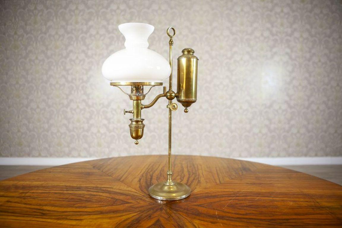 Lampe Kerosene du début du 20e siècle avec abat-jour en verre blanc

Lampe à pétrole antique en laiton, avec pied et hauteur réglable. Le verre de la cheminée et l'abat-jour sont intacts. Le mécanisme de réglage de la mèche est fonctionnel. L'objet
