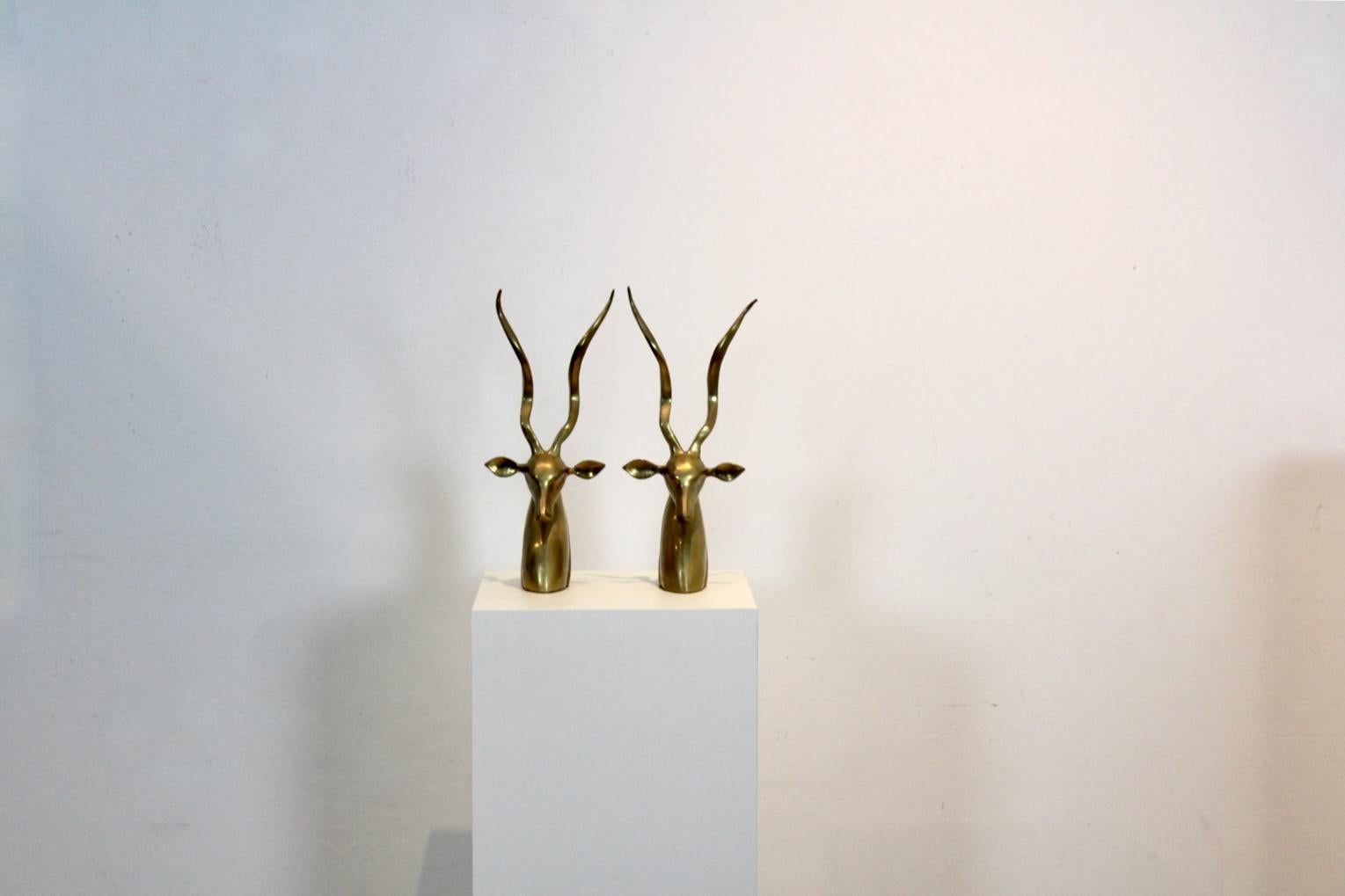 Exklusive und anmutige Kudu-/Antilopenbüsten aus Messing, entworfen von Karl Springer. Das Set besteht aus zwei massiven Messingbüsten mit hohen gedrehten Hörnern. Das Werk weist eine gewisse Asymmetrie auf, die die organische Natur des Themas