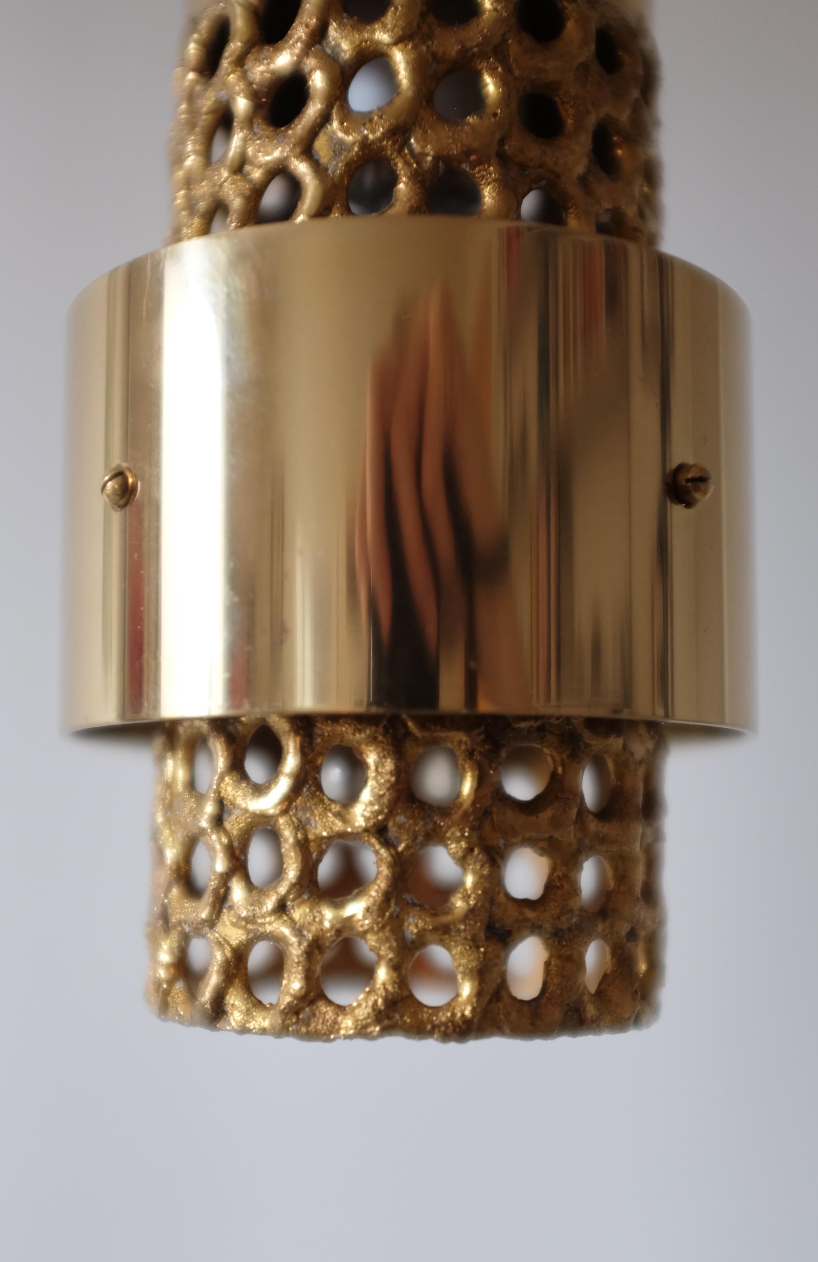 Pendentif en laiton perforé de Pierre Forssell pour Skultuna, Suède. Conçue à l'origine dans les années 1960, cette lampe est l'un des modèles emblématiques de lampes et de lanternes que Forssell a conçus pendant ses années d'activité à Skultuna,