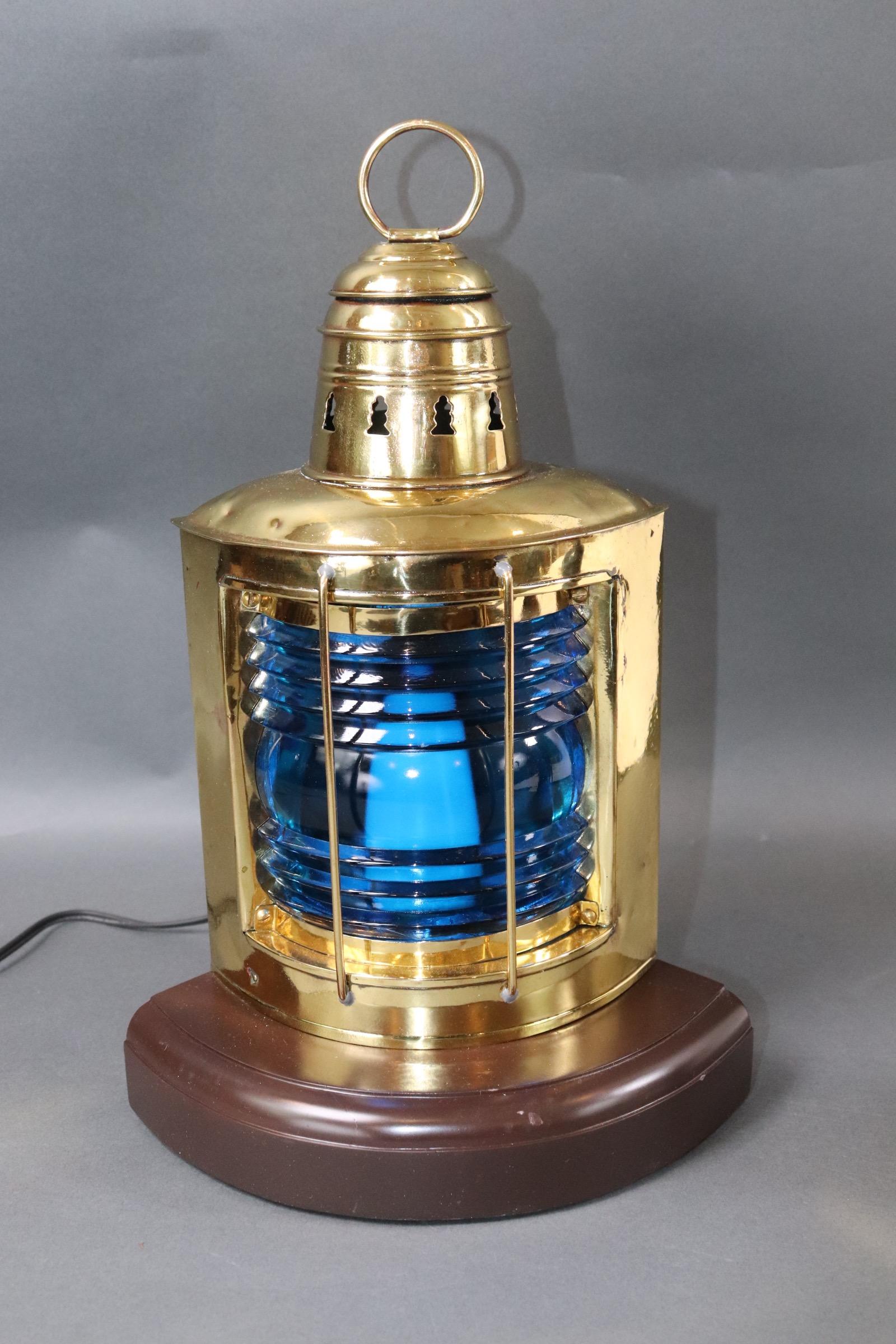 Solid brass highly polished starboard ships lantern with rich blue fresnel lens. Mounted to a custom wood base with rich dark finish. Engraved 