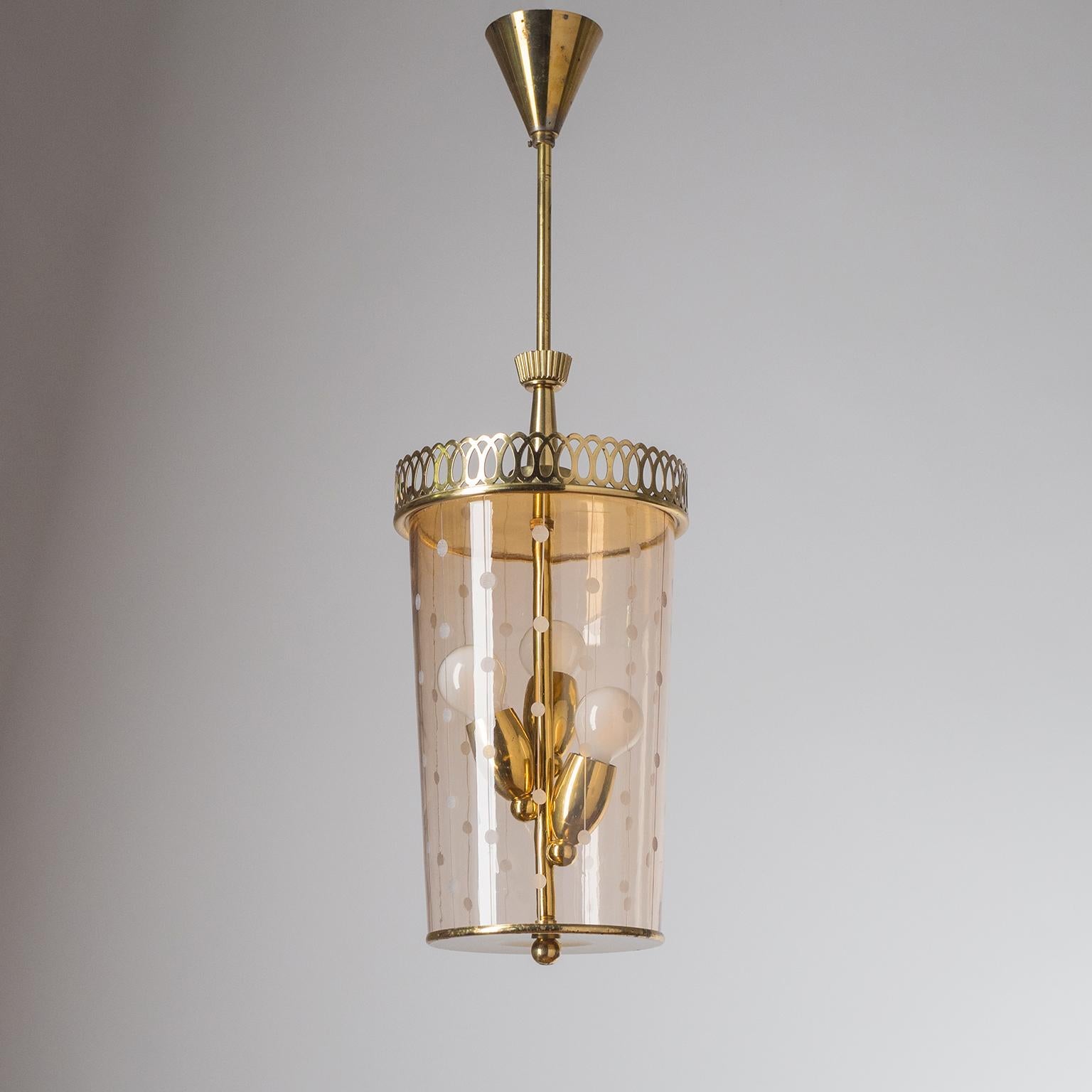 Rare brass lantern from the 1940-1950s. Lovely detailed brass elements with a rosé-tinted blown glass body with etched and cut decorations. Three original brass E14 sockets. Height without the stem is 16inches/41cm.
