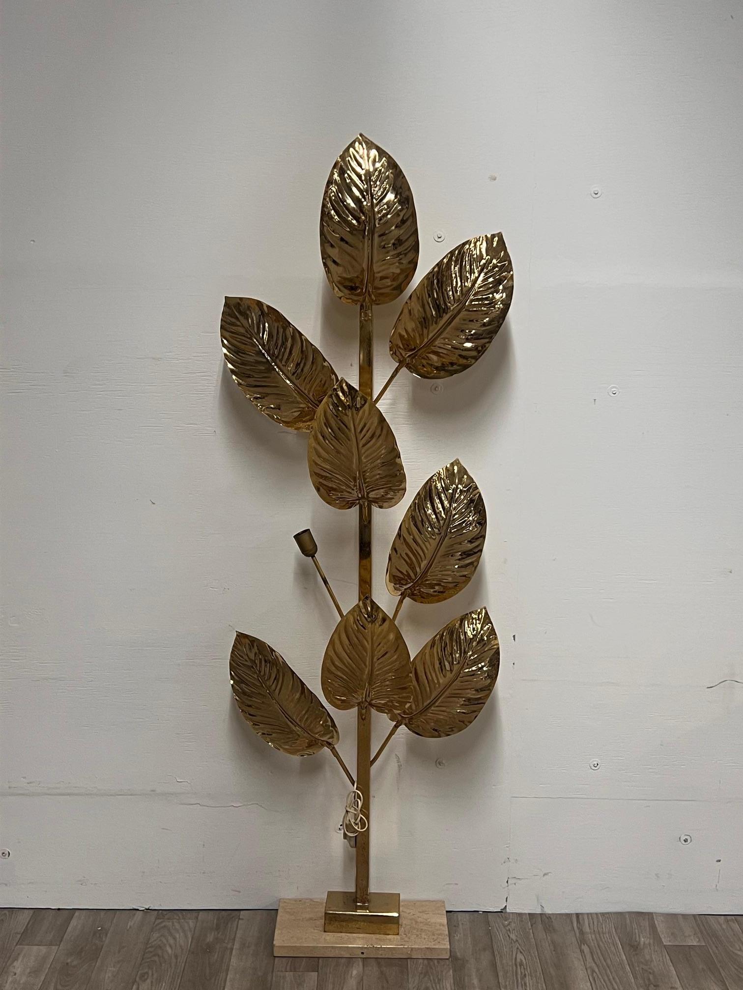 Lampada da terra a nove luci in ottone, Italia, anni '70. 
Struttura a sezione quadrata, paralumi a forma di foglia cesellata, appoggiati su una base rettangolare in marmo bianco.
(manca una foglia)
Ha bisogno di essere ricablato