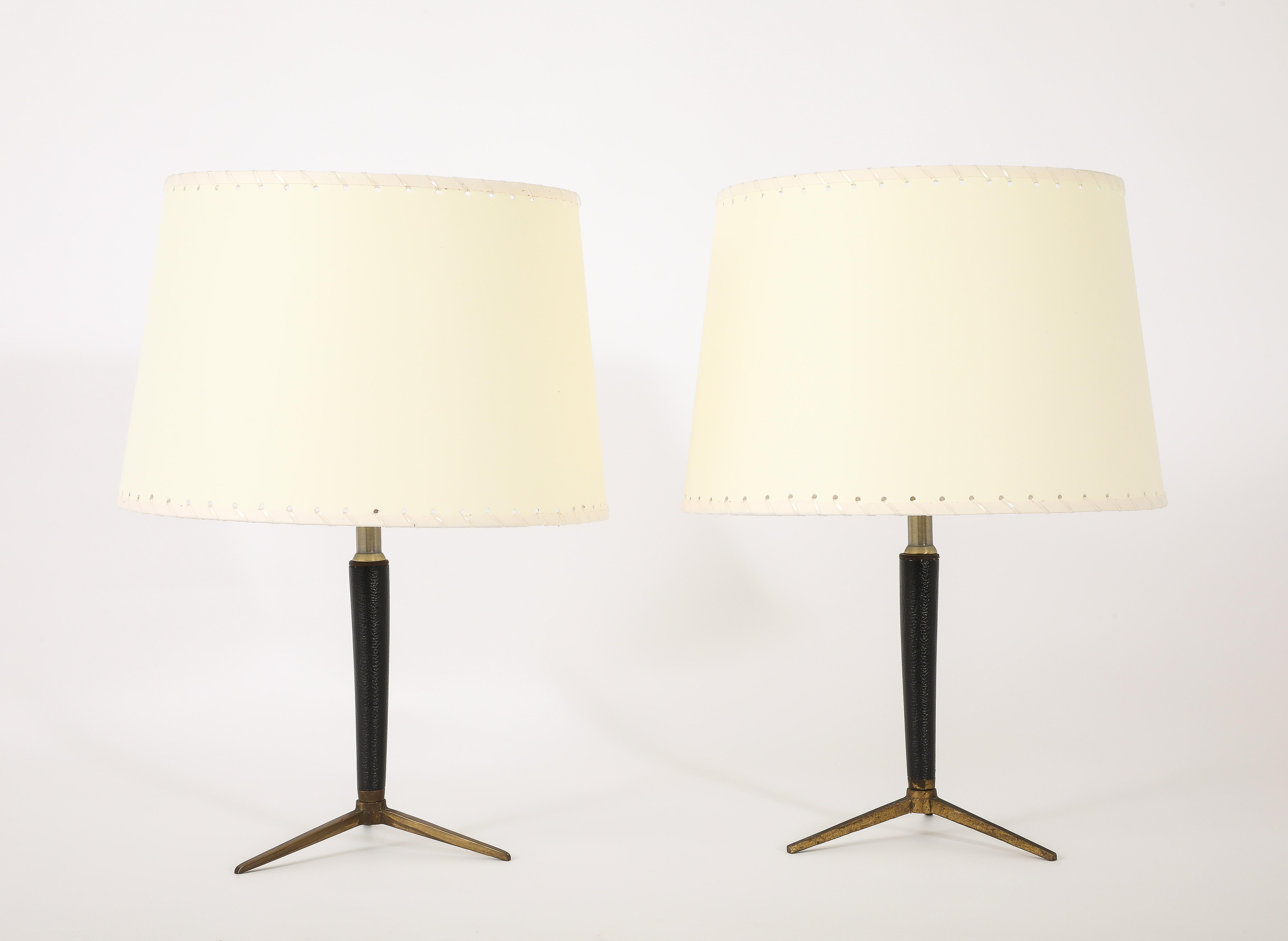 Tripod table lamps with stitched tapered leather stem.