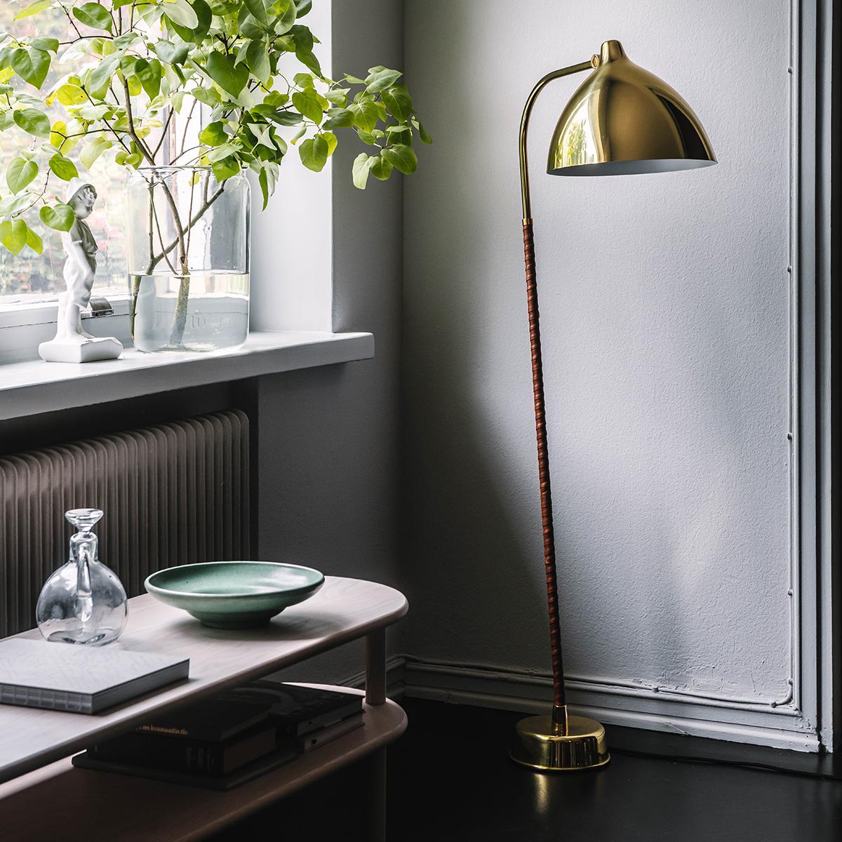 Lisa floor lamp is a grand design classic originally designed by Lisa Johansson-Pape for Orno Finland. 
The beautiful bell-shaped, genuine heavy brass dome effectively reflects the light downwards. The cognac coloured, hand-crafted leather finish