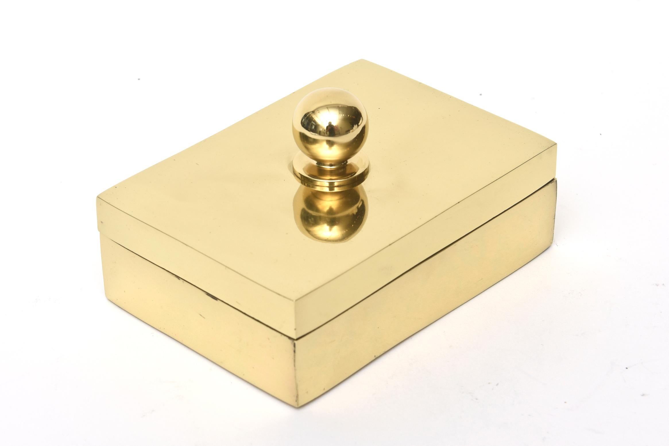This lovely 2 part polished brass lidded box has a ball top. It is vintage from the 1970s and makes a great desk accessory or cocktail table addition. The lining is black velvet. It has been professionally polished. The old label on the bottom is