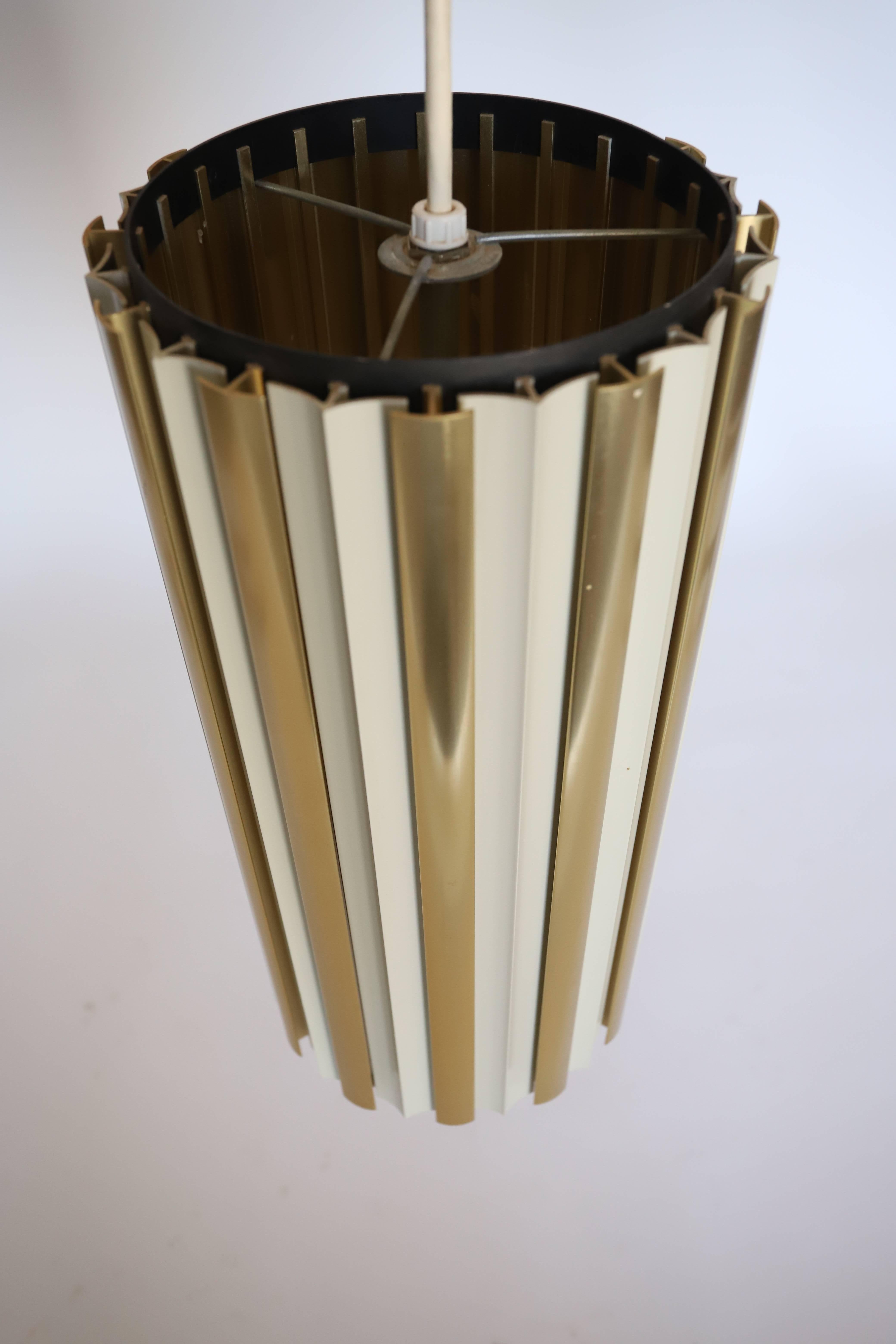 Die röhrenförmige Lightolier Pendelleuchte mit Raster ist eine moderne und vielseitige Leuchte, die schlankes Design mit effektiver Beleuchtung kombiniert. Die röhrenförmige Form und der Schirm mit Lamellen machen sie zu einer stilvollen Ergänzung