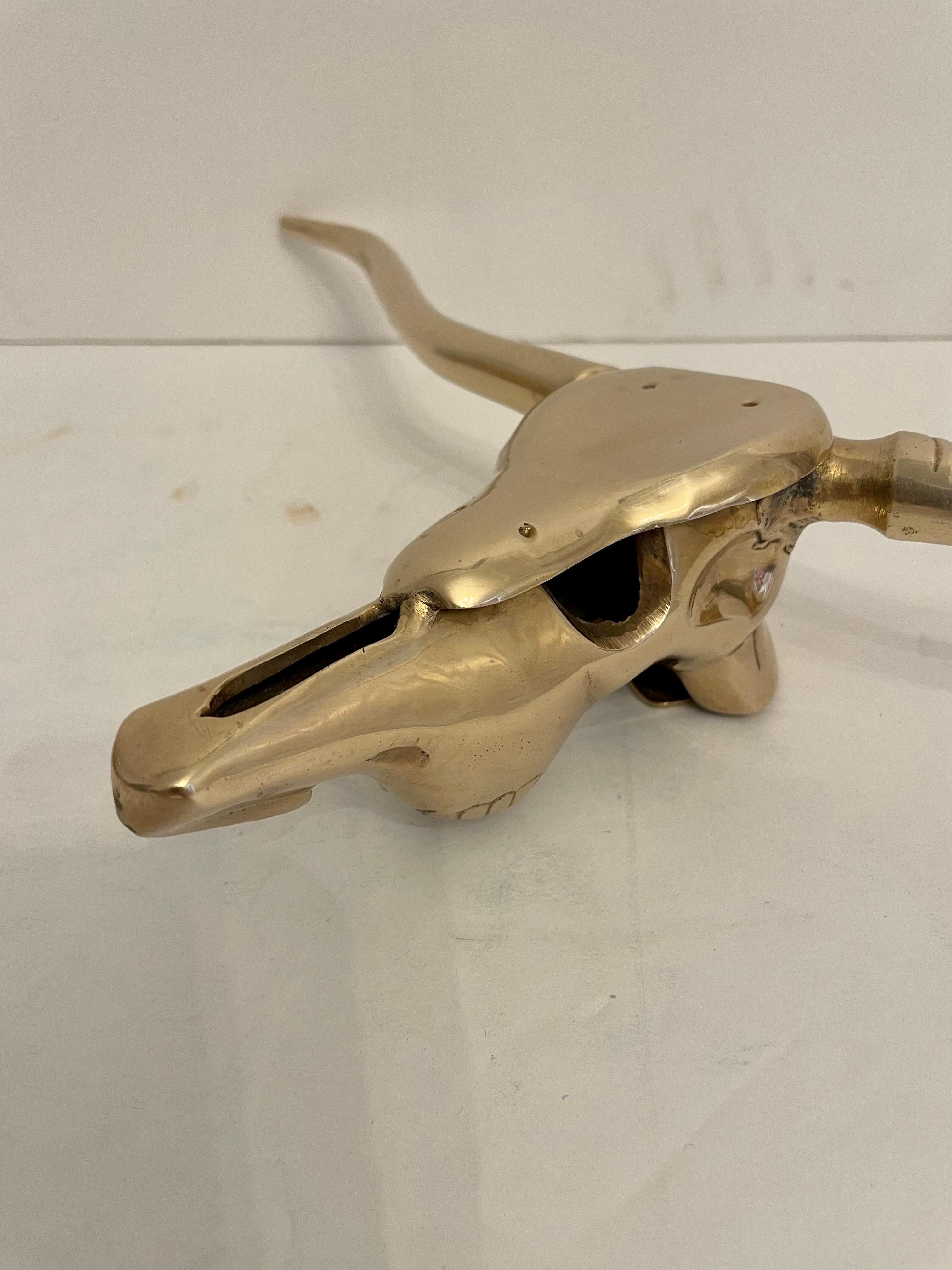 Circa late 20th century Hollywood Regency style decorative brass longhorn skull wall sculpture in a hand polished finish. Please note of wear consistent with age. Good overall condition.