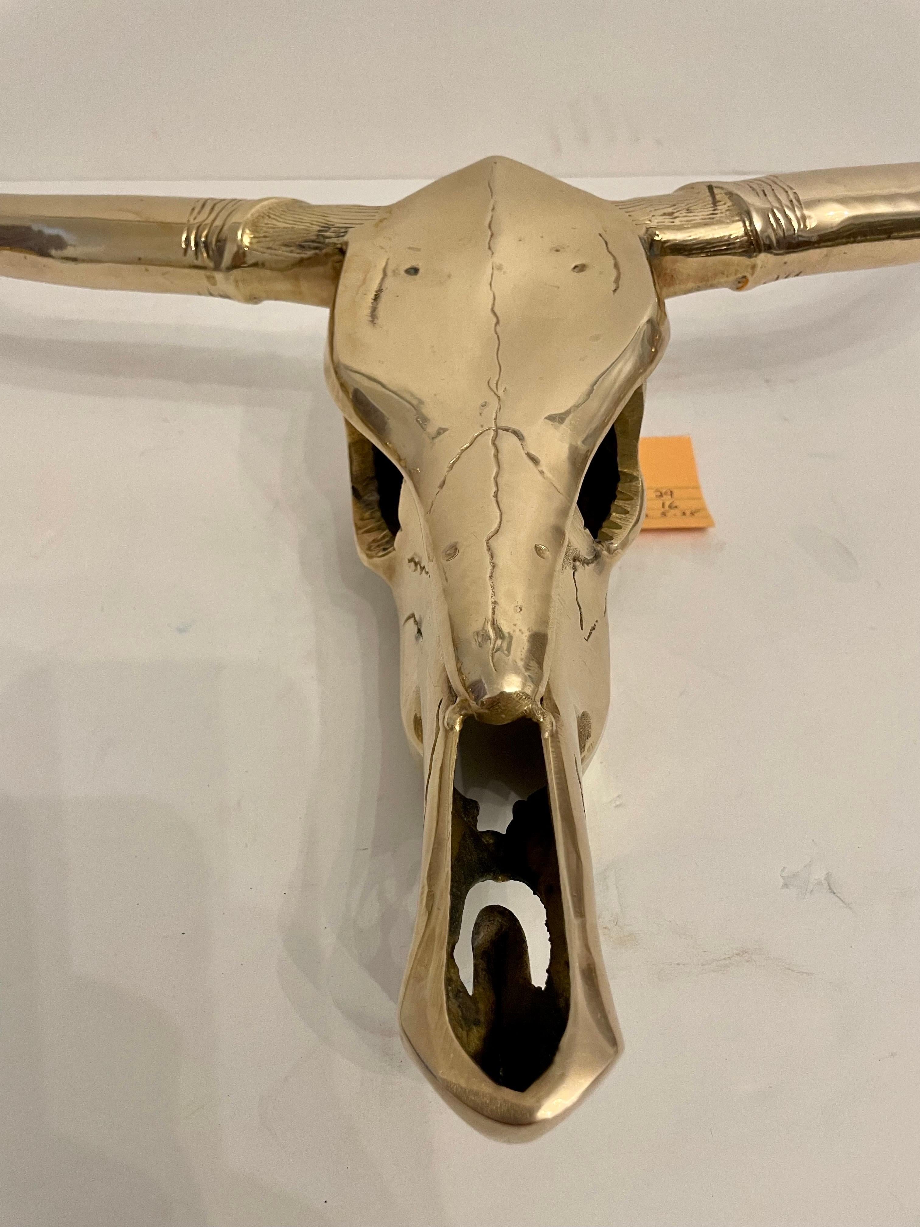 Circa mid-20th century Hollywood Regency style decorative brass longhorn skull wall sculpture in a hand polished finish. Please note of wear consistent with age. Good overall condition.