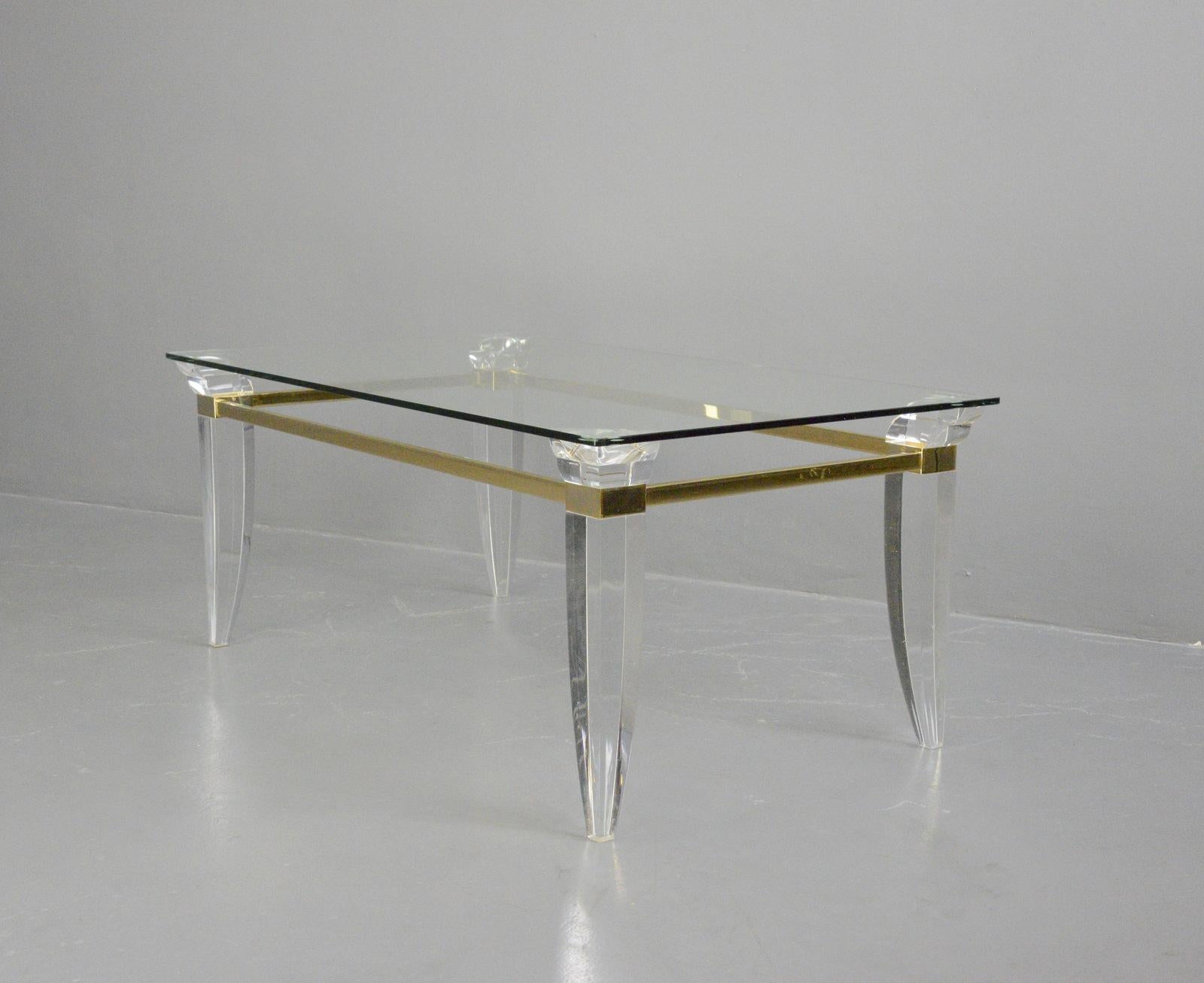 Brass & lucite coffee table Circa 1970s

- Swept Lucite legs
- Brass banding detail
- Toughened glass top
- French ~ 1970s
- Measures: 120cm long x 70cm deep x 51cm tall

Condition report

Some scratches to the glass top in places.