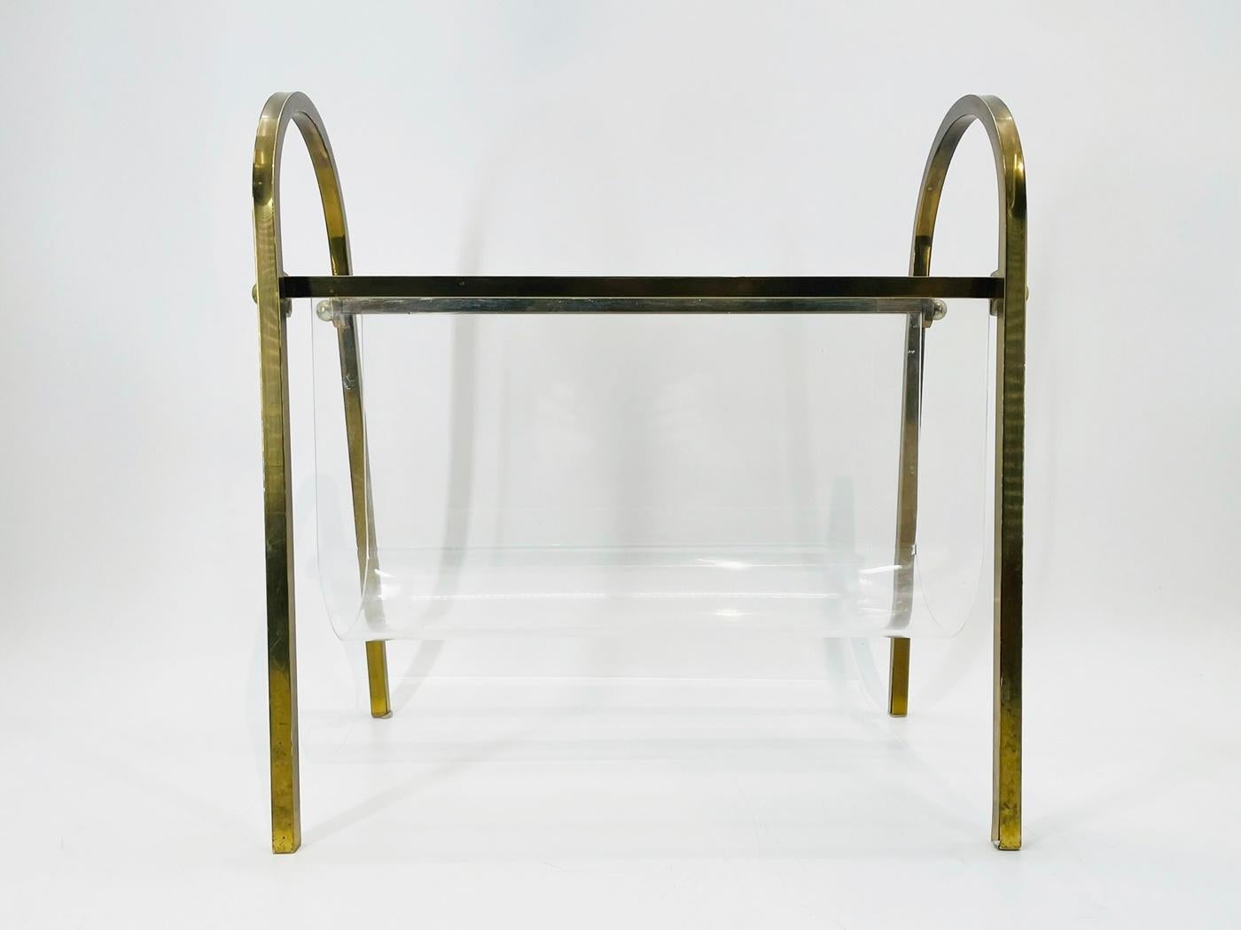 Add a touch of sophistication to your living space with this exquisite Brass & Lucite Magazine Holder by renowned designer Charles Hollis Jones. Crafted in the USA during the 1960s, this stunning piece features a sleek gold metal stand with