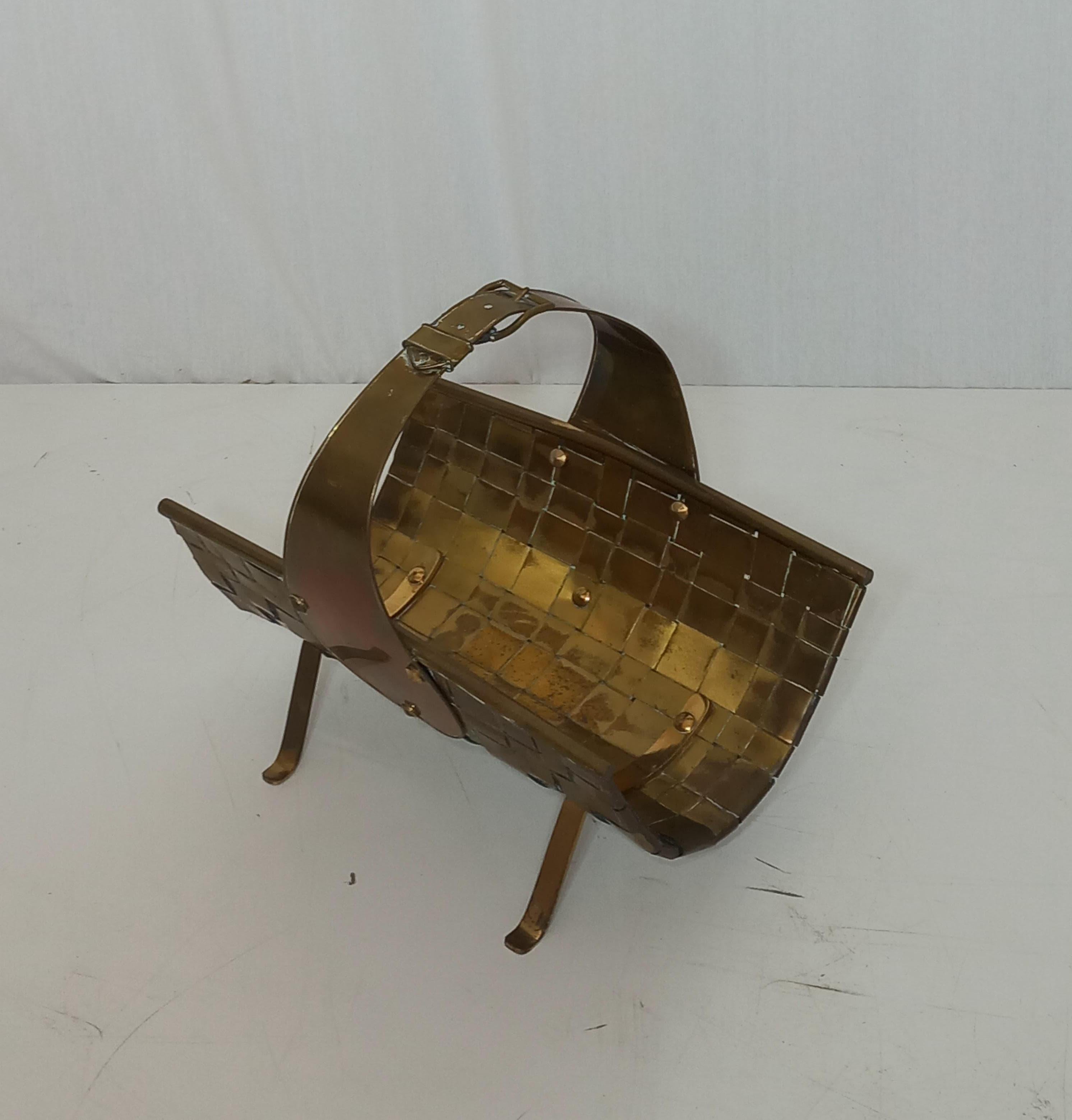 Ce porte-revues a été fabriqué dans les années 40 et est en laiton. Ses lignes courbes ajoutent une touche d'élégance. Plus qu'un simple objet de rangement, il s'agit d'une pièce d'artisanat singulière. Son design ressemble à un seau en osier avec