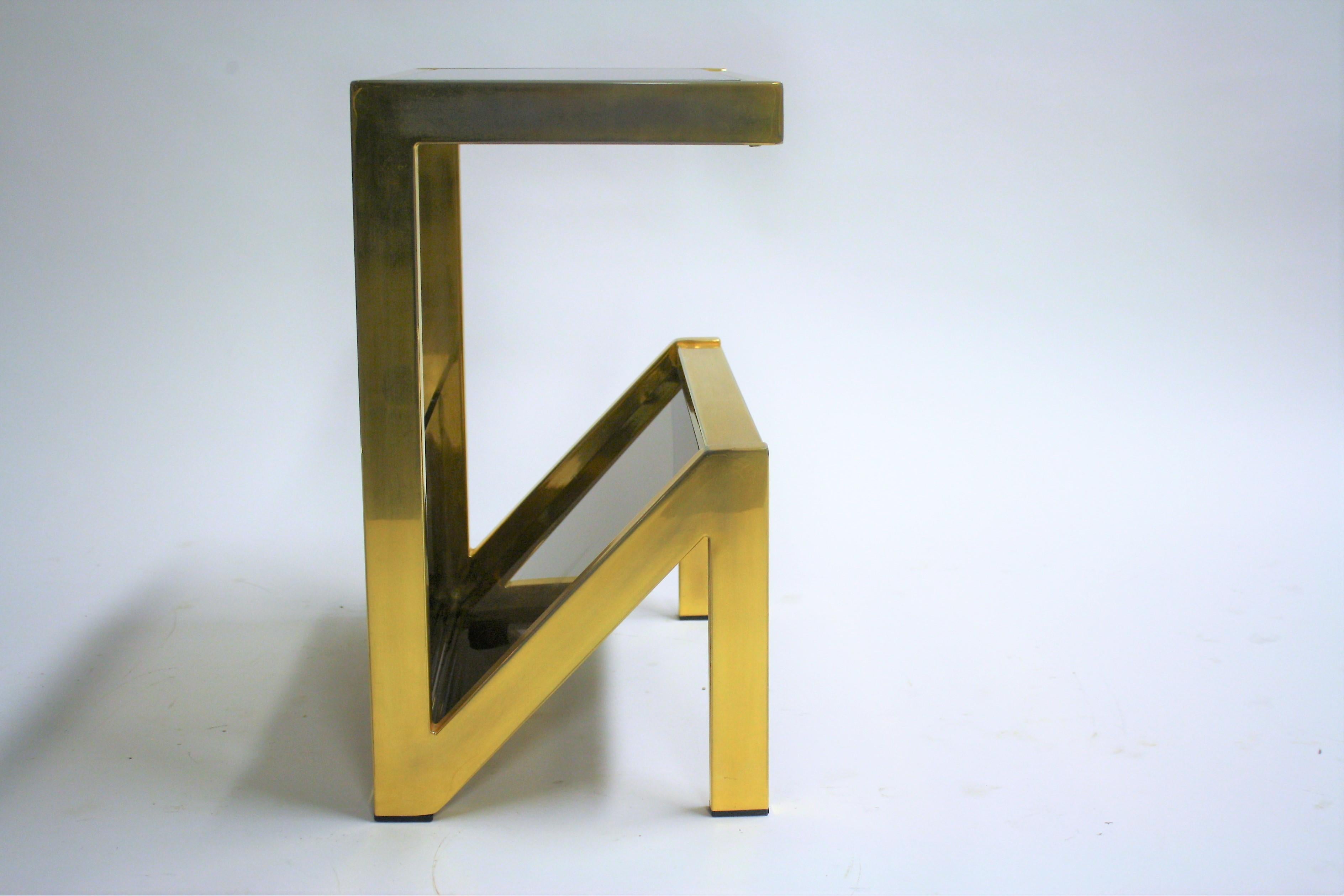 Seventies brass and smoked glass side table with magazine holder.

This table has a N shaped frame.

All original glass, no damages. Slightly faded brass on one side.

1970s - Belgium

Measures: Height 51cm/20
