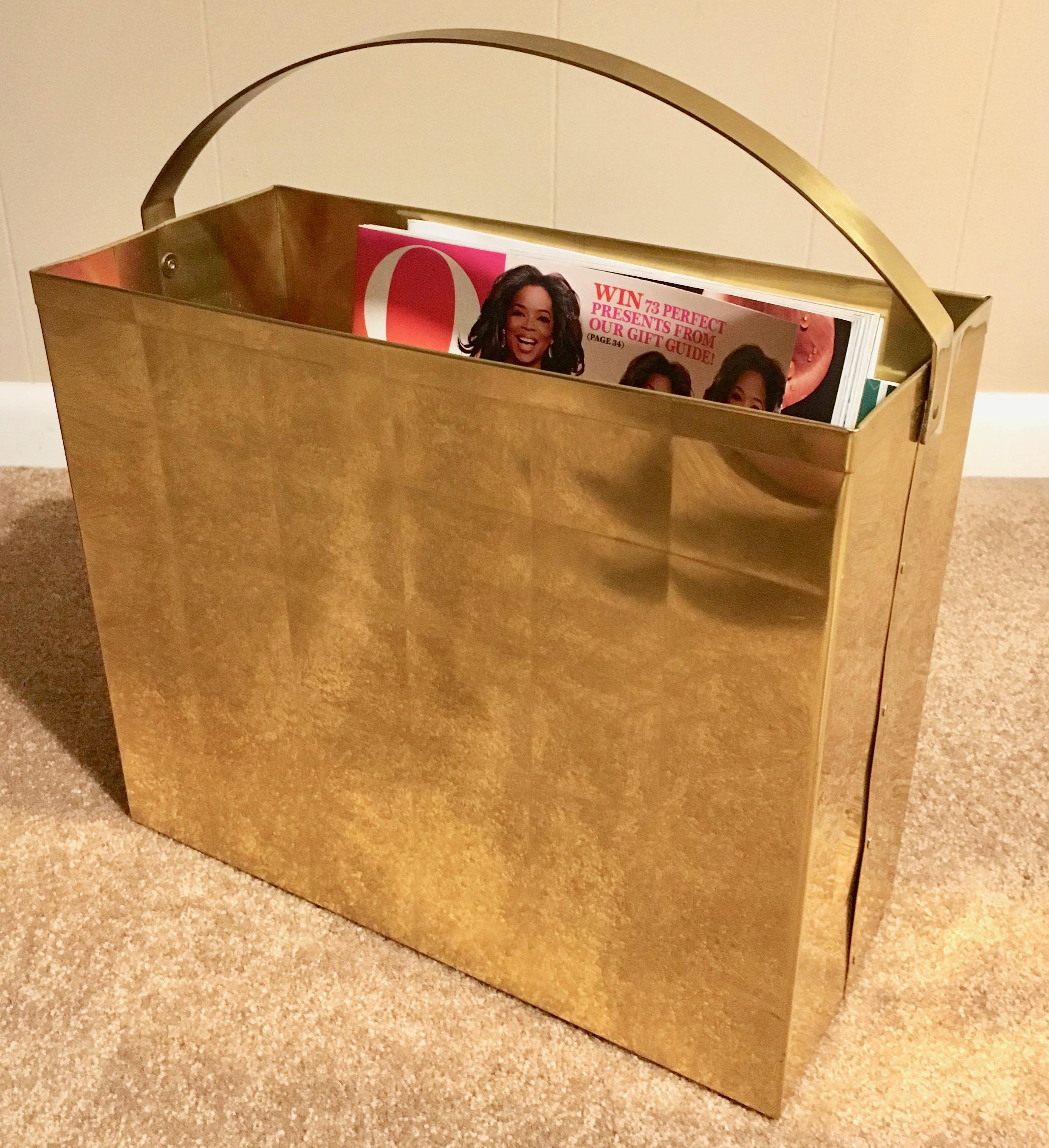 A brass trash bin or magazine rack, a handsome piece with a 'quilted' look outside with a handle, looks similar to a shopping bag, easily moved, a very nice look for any bedroom, office, den. A great place to store magazines from architectural