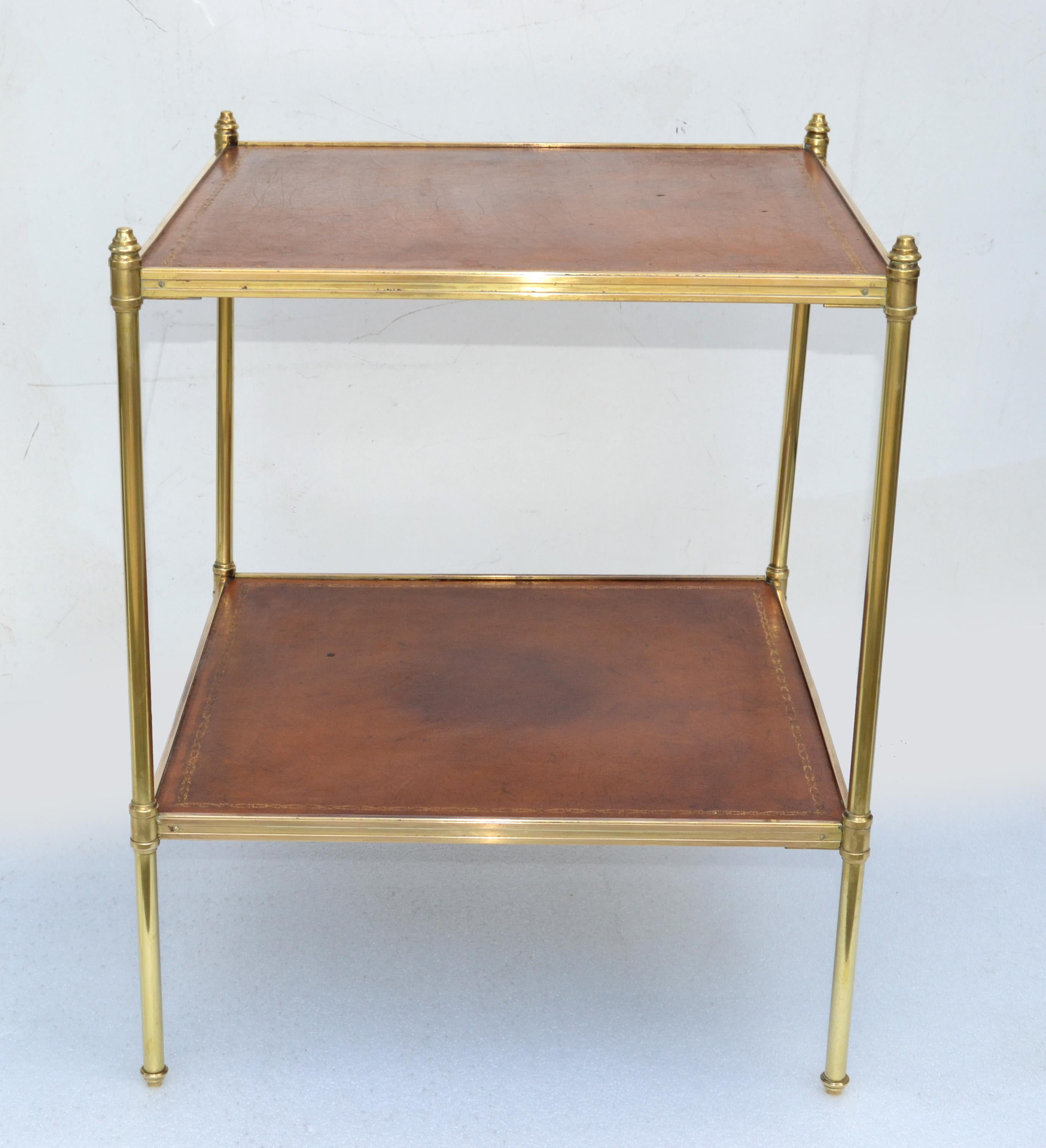 French Neoclassical Maison Jansen brass square side, end, drink table with 2 Tier light Brown Tops.
Raised on 4 polished fine legs and the surface inset gilt tooled & gold border leather tops.
Made in France in the 1950.
Space in between Tiers