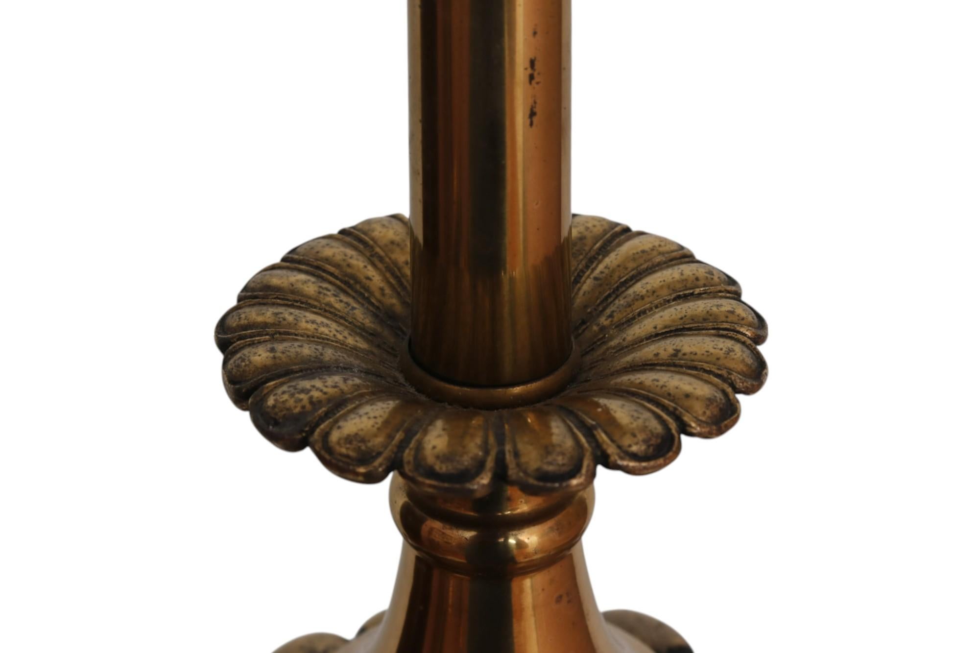 A brass and marble column table lamp. The central brass column is fluted, topped with a gadrooned knop and floral drip pan. The lamp is supported below with a square marble plinth base on round brass feet. Measures 6