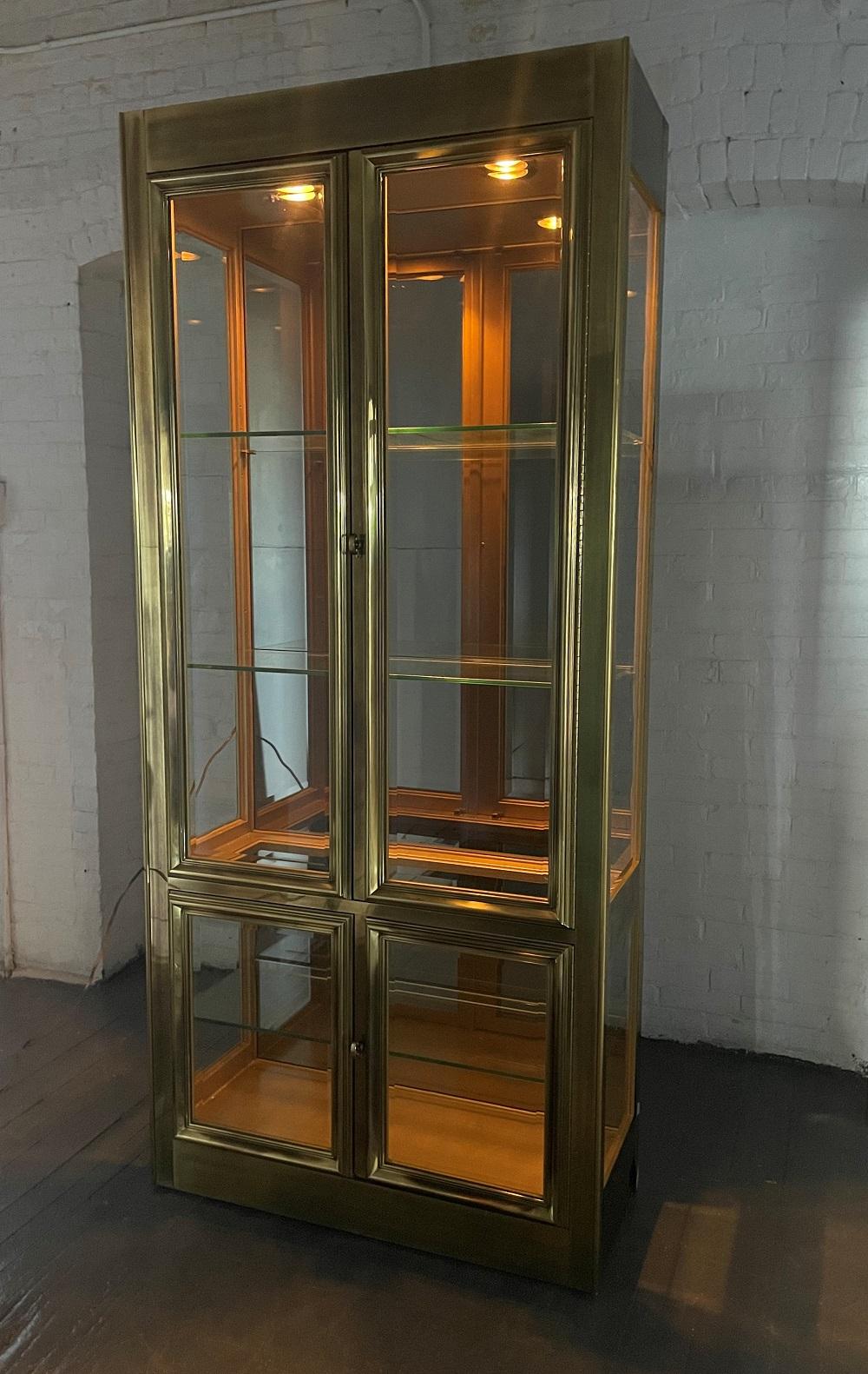 Brass mastercraft display cabinet. The cabinet has glass shelves and lights up inside from top.