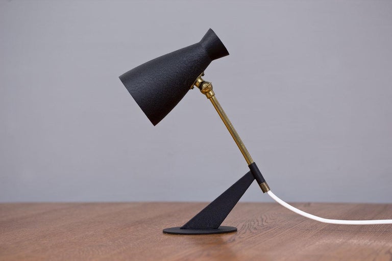 1950s table lamp, from unknown maker.
Most likely from Germany. Aluminum
Reflector and metal base with black crackle
Finish. Brass stem. Rewired with original
Light switch on the cord in working order.