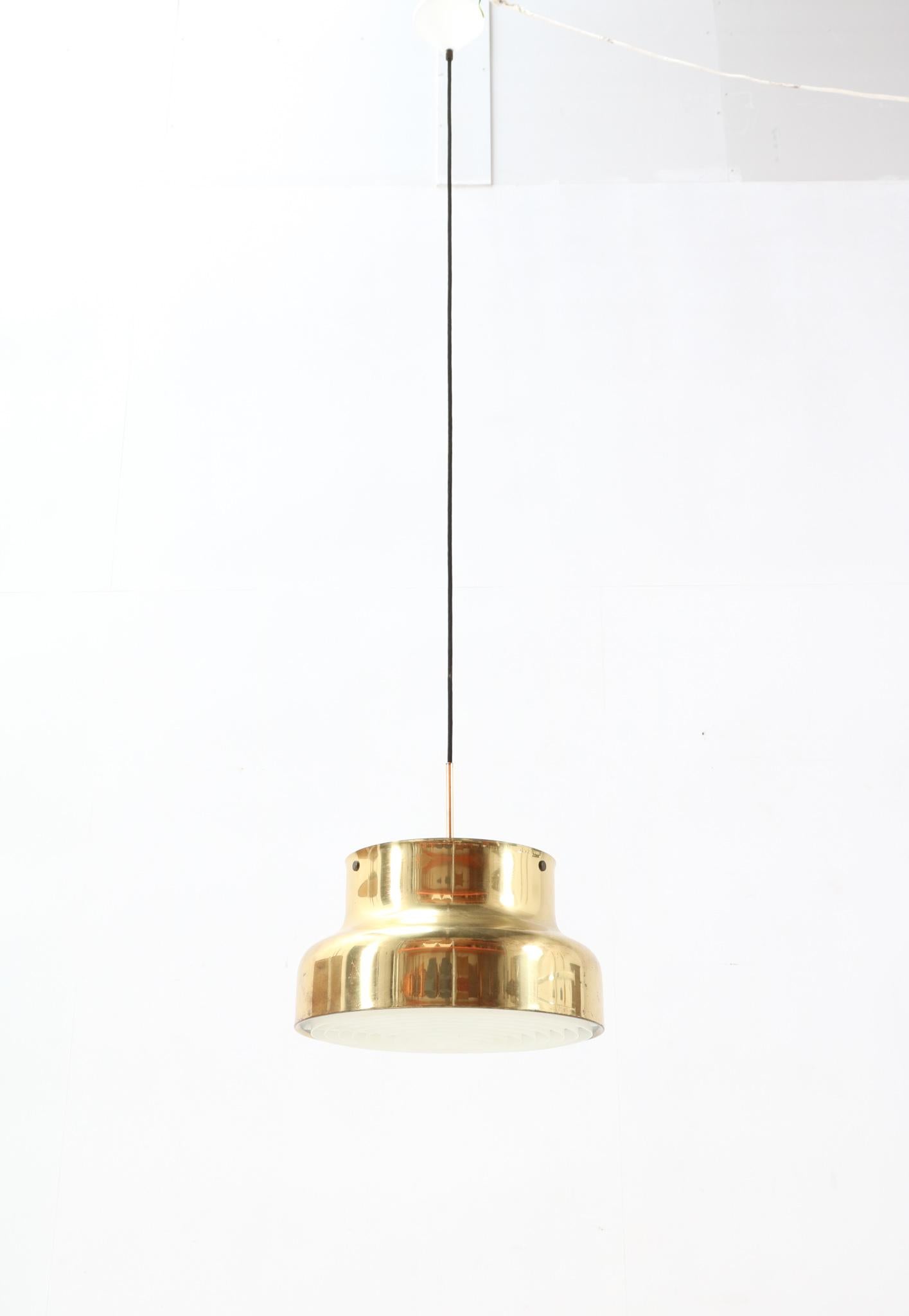 Elegant Mid-Century Modern Bumling pendant light.
Design by Anders Pehrson for Ateljé Lyktan.
Striking Swedish design from the 1960s.
Solid brass shade with the original light-softening acrylic bottom shade.
The original on/off switch is on top