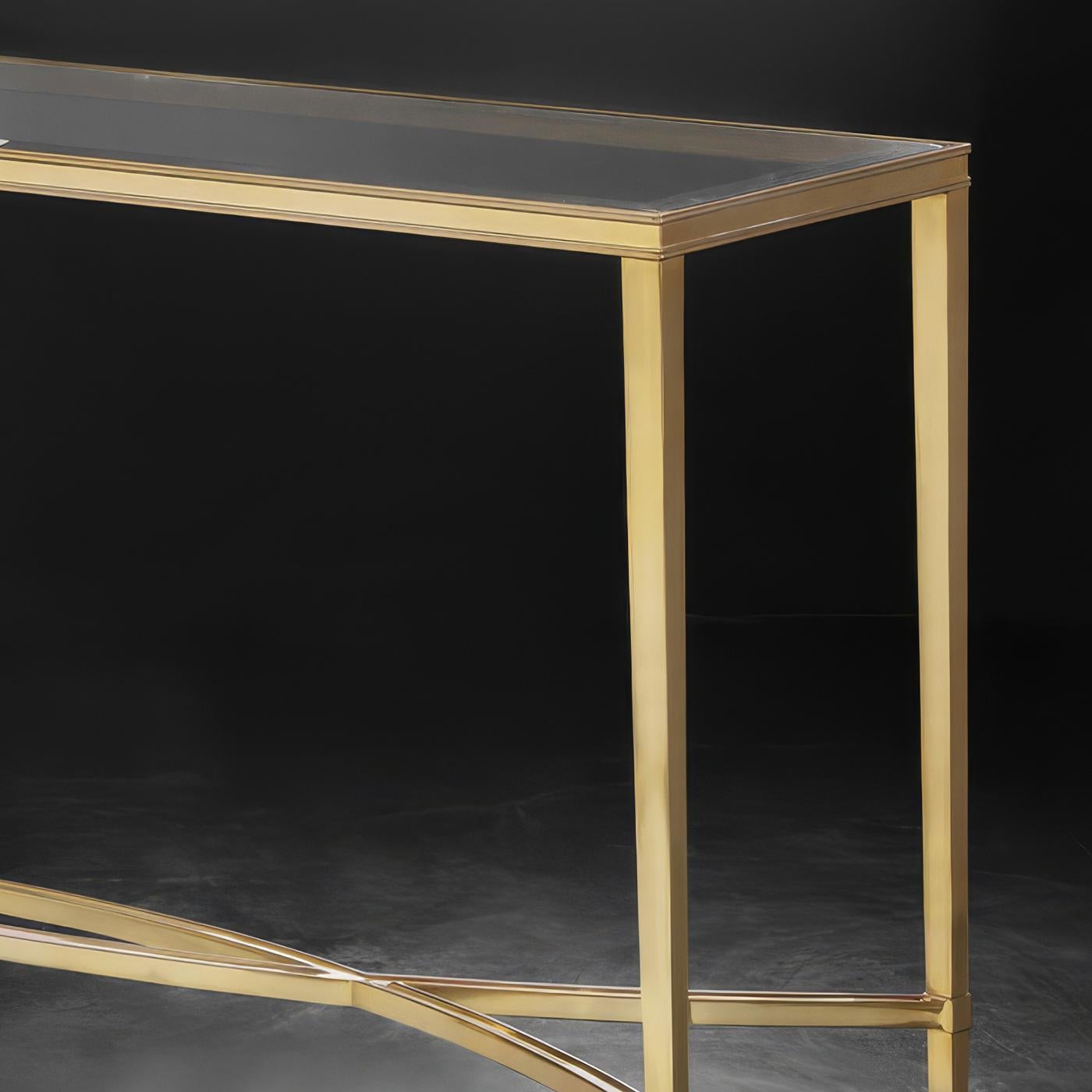 Realizzata con una struttura in ottone lucido, la sua struttura elegante emana lusso, mentre il piano in vetro trasparente temperato offre un contrasto raffinato. Il suo design delicato ma robusto lo rende perfetto per ingressi, salotti o