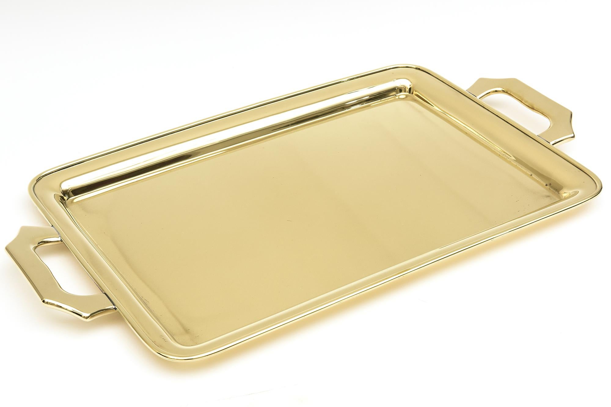 This heavy gauge brass tray is Mid-Century Modern and from the 50's. It has been beautifully polished professionally and lacquered. Our restorer says it is bronze but we are calling it brass. The handles are very comfortable to serve. Modern looking