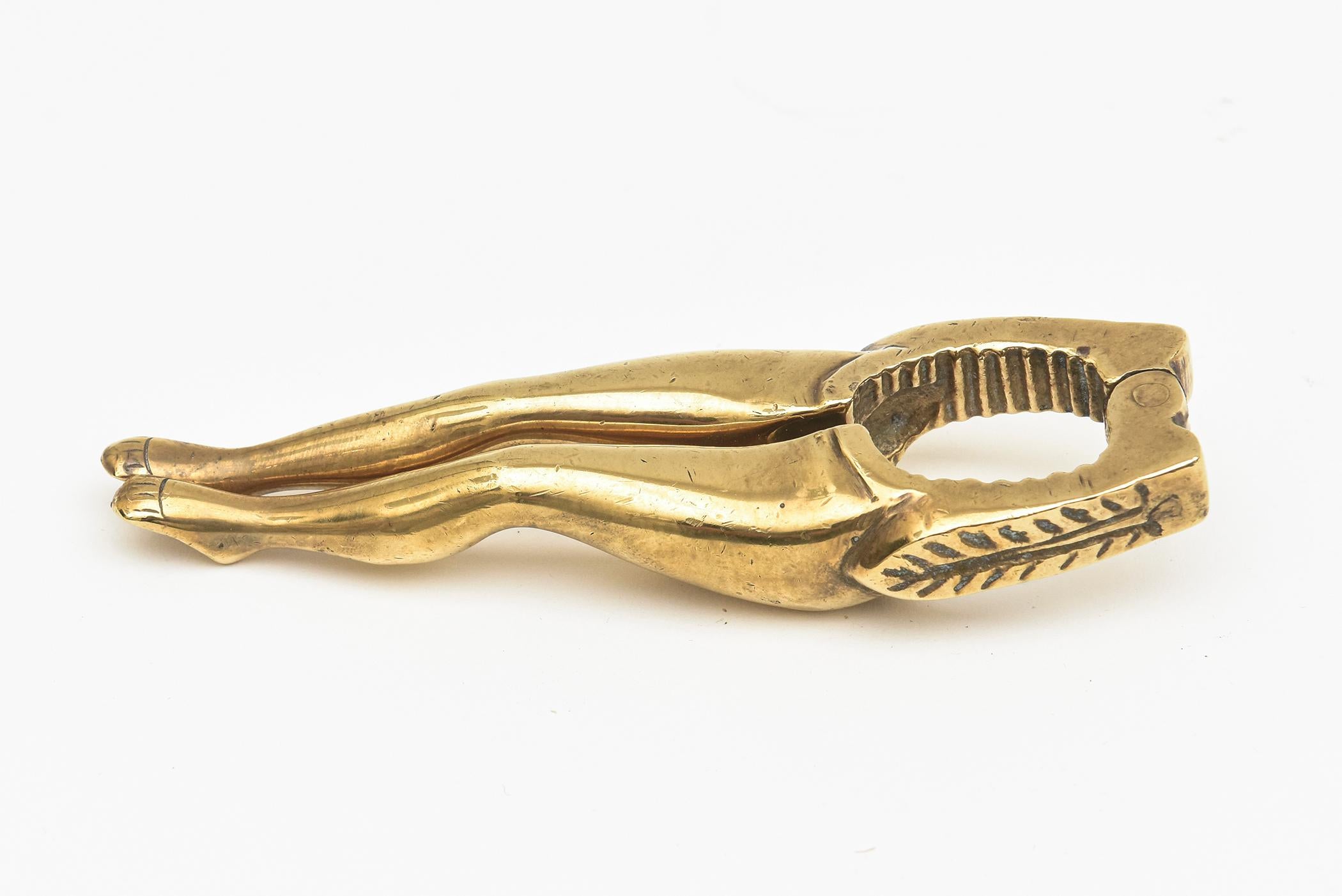 This fun conversational brass nut cracker with legs is mid century modern. It has been lightly polished and has a leaf pattern design on the sides. From the 50's. Great barware or host gift idea.