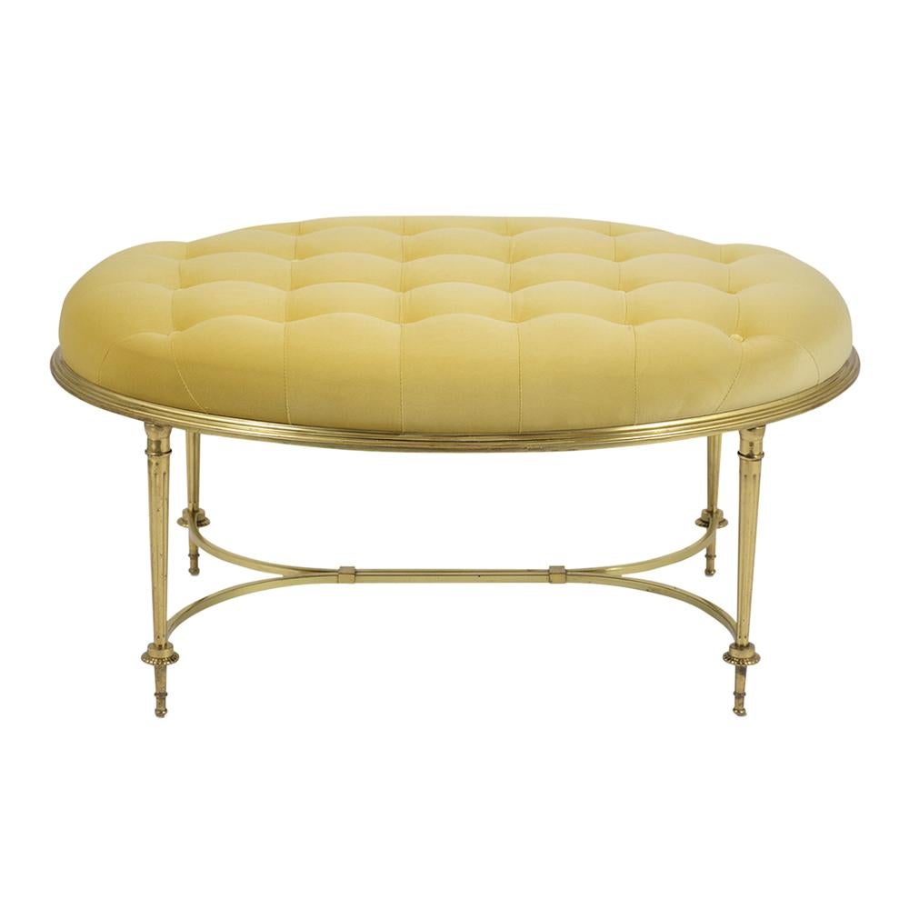 This elegant midcentury style bench is beautifully crafted out of brass features an oval design with a comfortable tufted seat cushion. This fabulous ottoman has been newly upholstered in yellow velvet fabric and a new foam insert. This modern