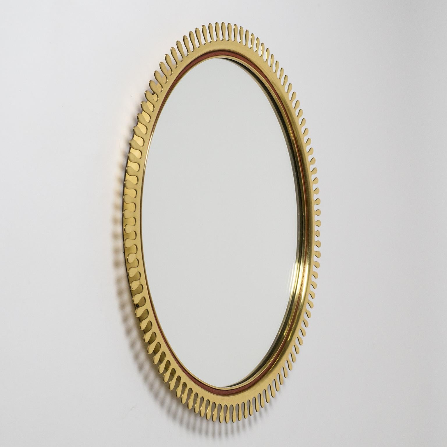 Brilliant brass sun mirror from the 1950s. Produced by renowned Bavarian design collective Vereinigte Werkstätten München this features an impeccable continuous brass rim with scalloped 