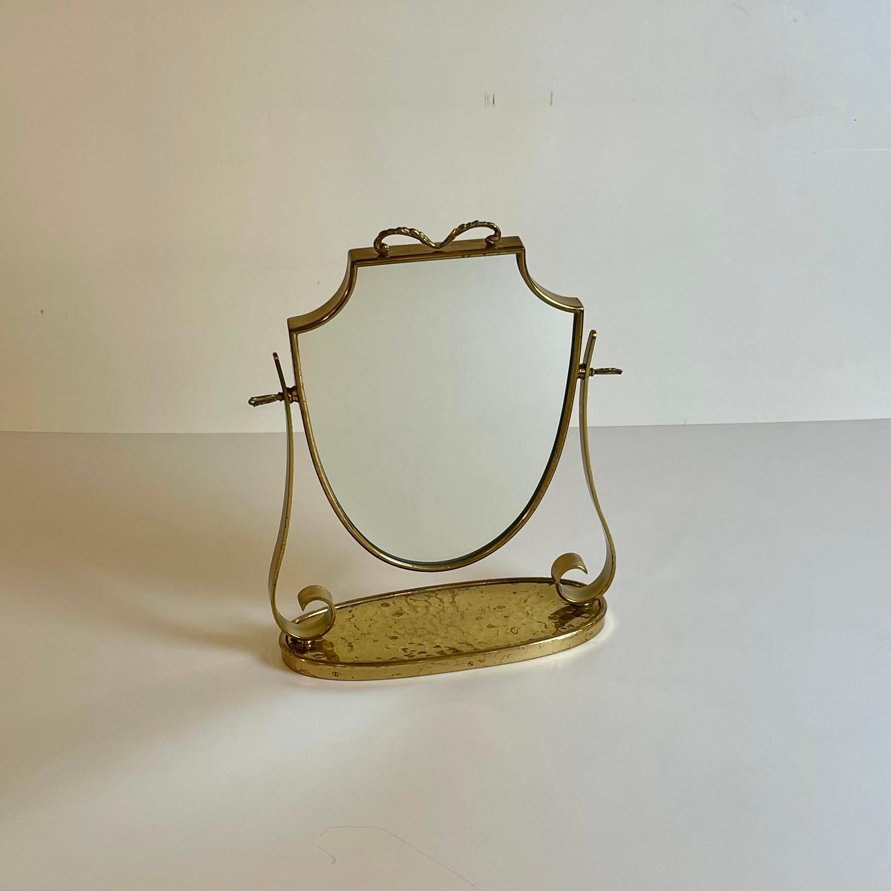 Bonito espejo de mesa italiano de latón con base martillada al estilo de Gio Ponti, de la década de 1940.
En muchos sitios web se atribuye este espejo al gran arquitecto y diseñador Gio Ponti.
Muy finamente elaborado con latón martillado y latón