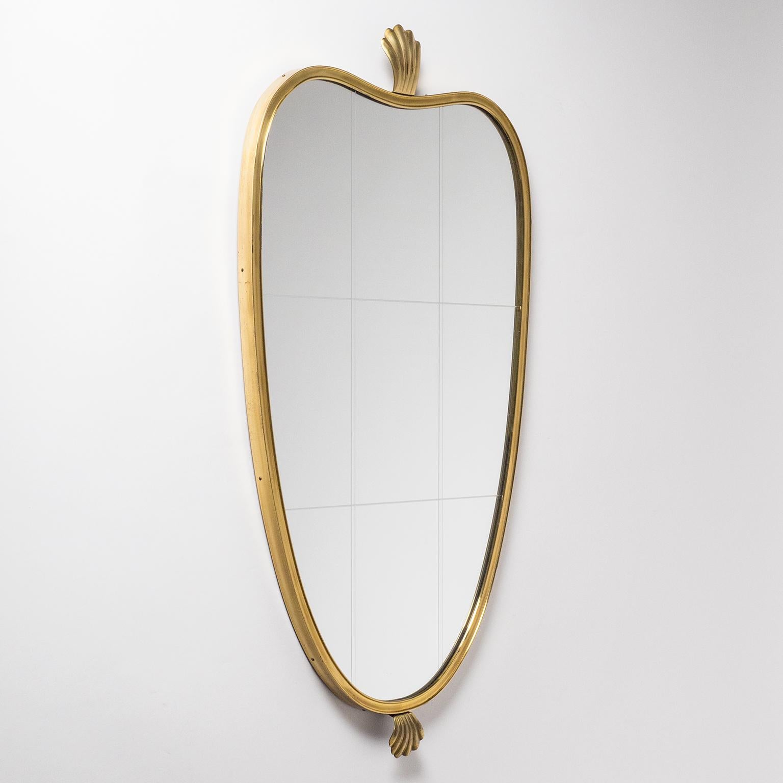 Beautiful midcentury heart shaped brass mirror with 'shell' finials on top and bottom. The original mirror has a large grid etched on the surface. Produced circa 1950 this mirror is in wonderful original condition with a light patina on the brass.