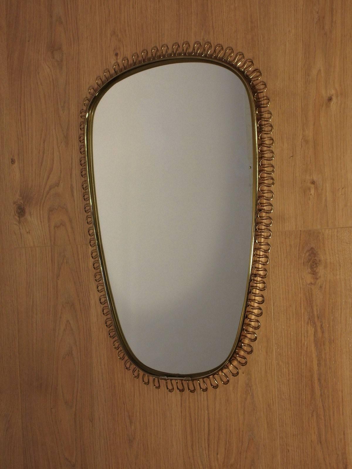 Scandinavian wood and metal mirror by Josef Frank for Svenskt Tenn, 1950s. Josef Frank was an Austro-Swedish architect. He is considered one of the founders of modern Swedish design. Its signature element on its mirrors, brass scrolls bordering the