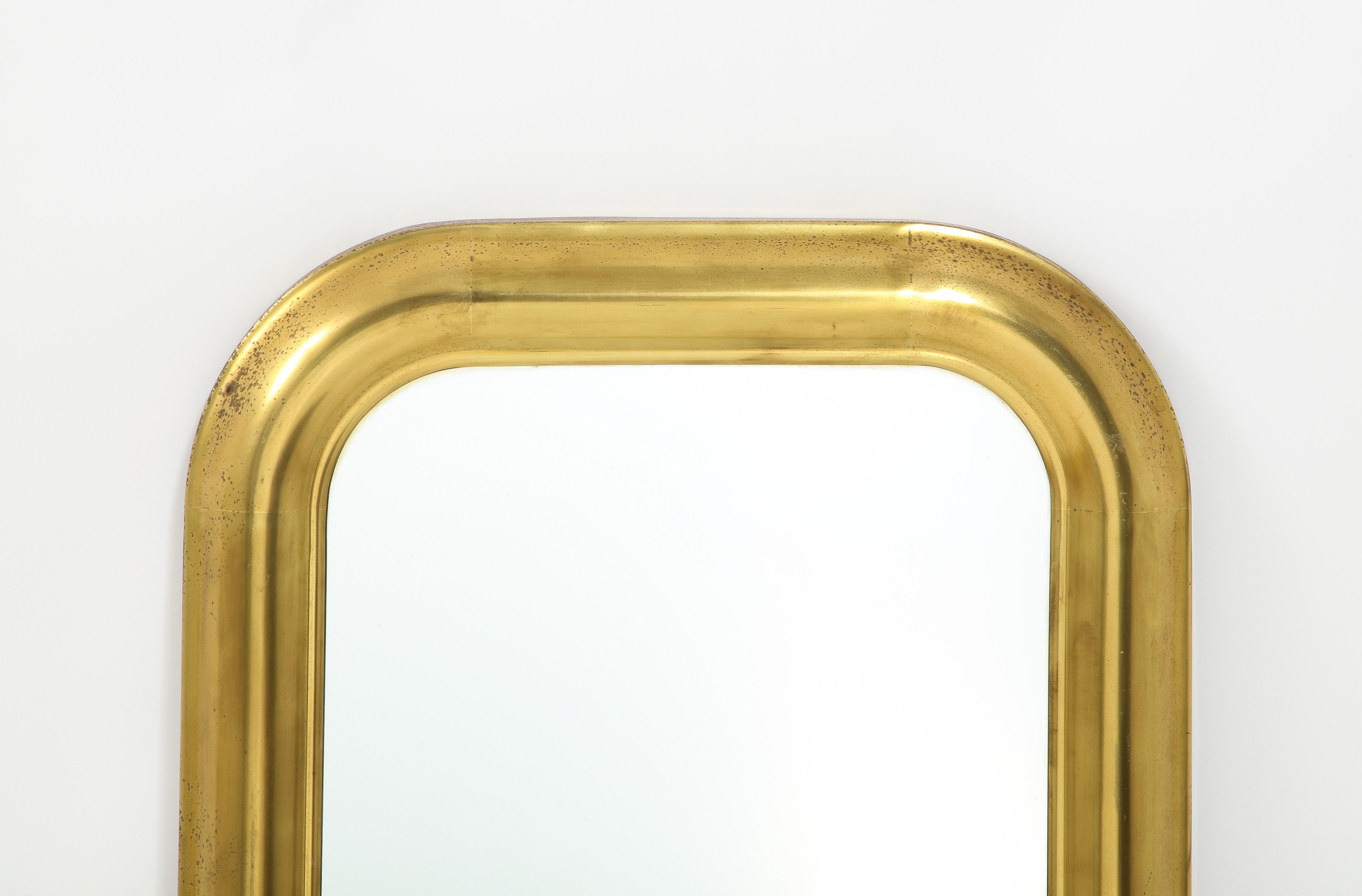 A medium-sized brass mirror, the frame was most likely stamp formed out of sheet metal, wood back and original glass.