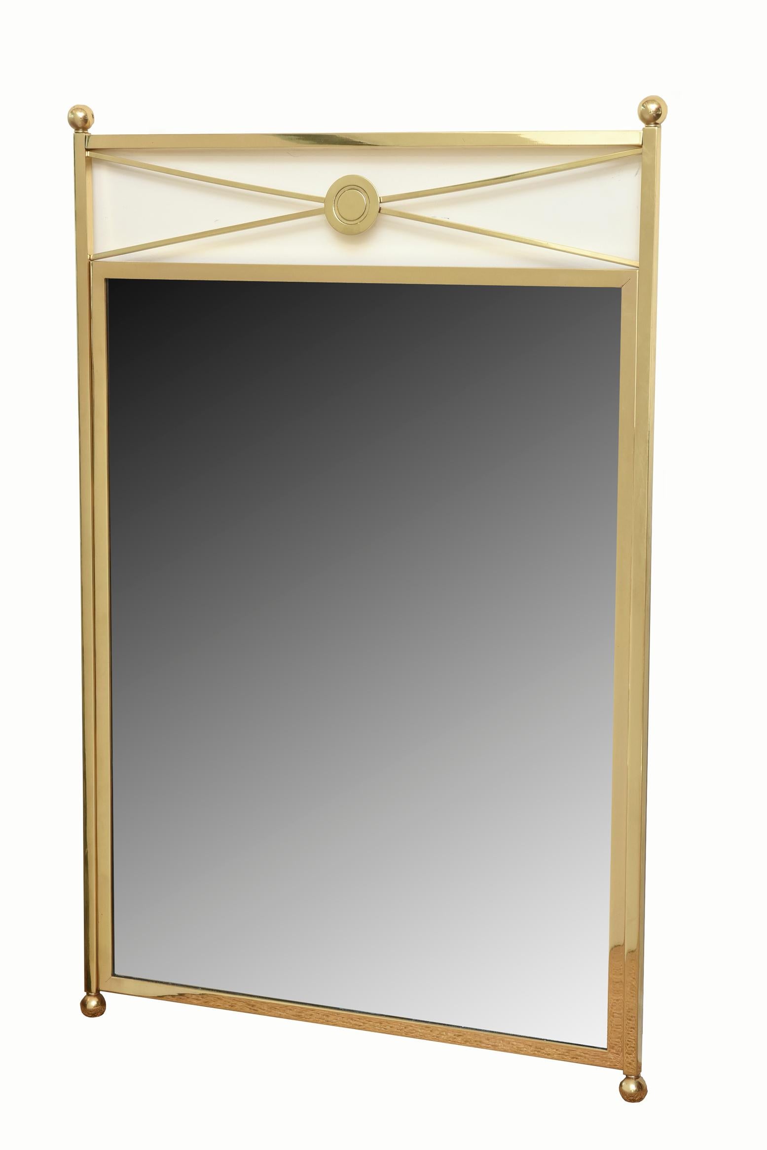 This very modernist designed vintage brass mirror with a French twist and William Billy Haines influence has elegance and simplicity with its ball toppings and crisscross medallion centered top. This is a timeless brass mirror that transcends all