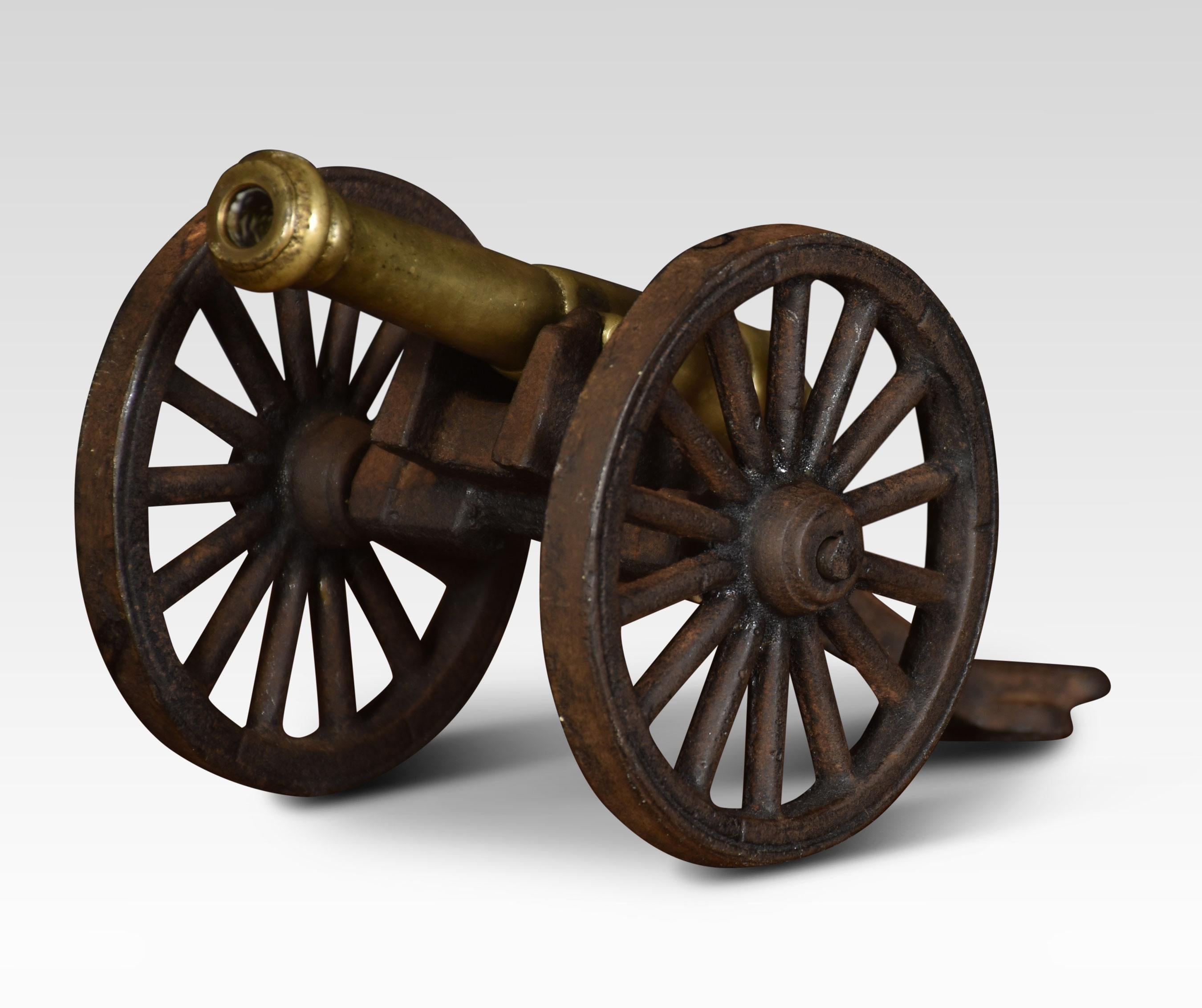 Moddel of a signal cannon with a brass barrel mounted on a wooden carriage with spoked wheels.
Dimensions
Height 4 inches
Width 4 inches
Depth 7.5 inches.