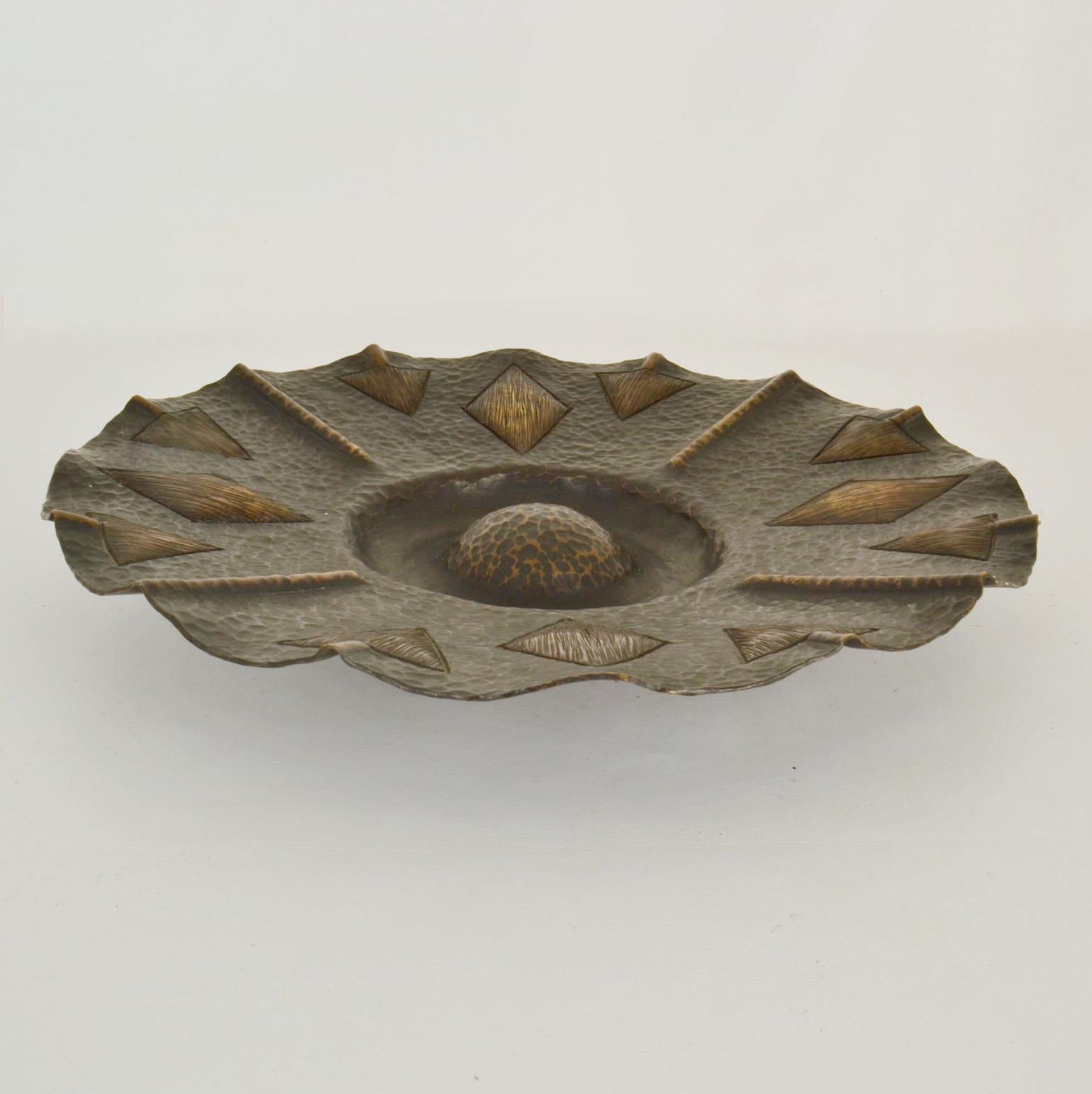 Brass bowl 1950s with flower shape relief and dark patina. Modernist hand-hammered bowl, decorative as a center piece and functional ad a fruit bowl. The hammering creates a decorative geometric pattern and its original patina creating depth to the