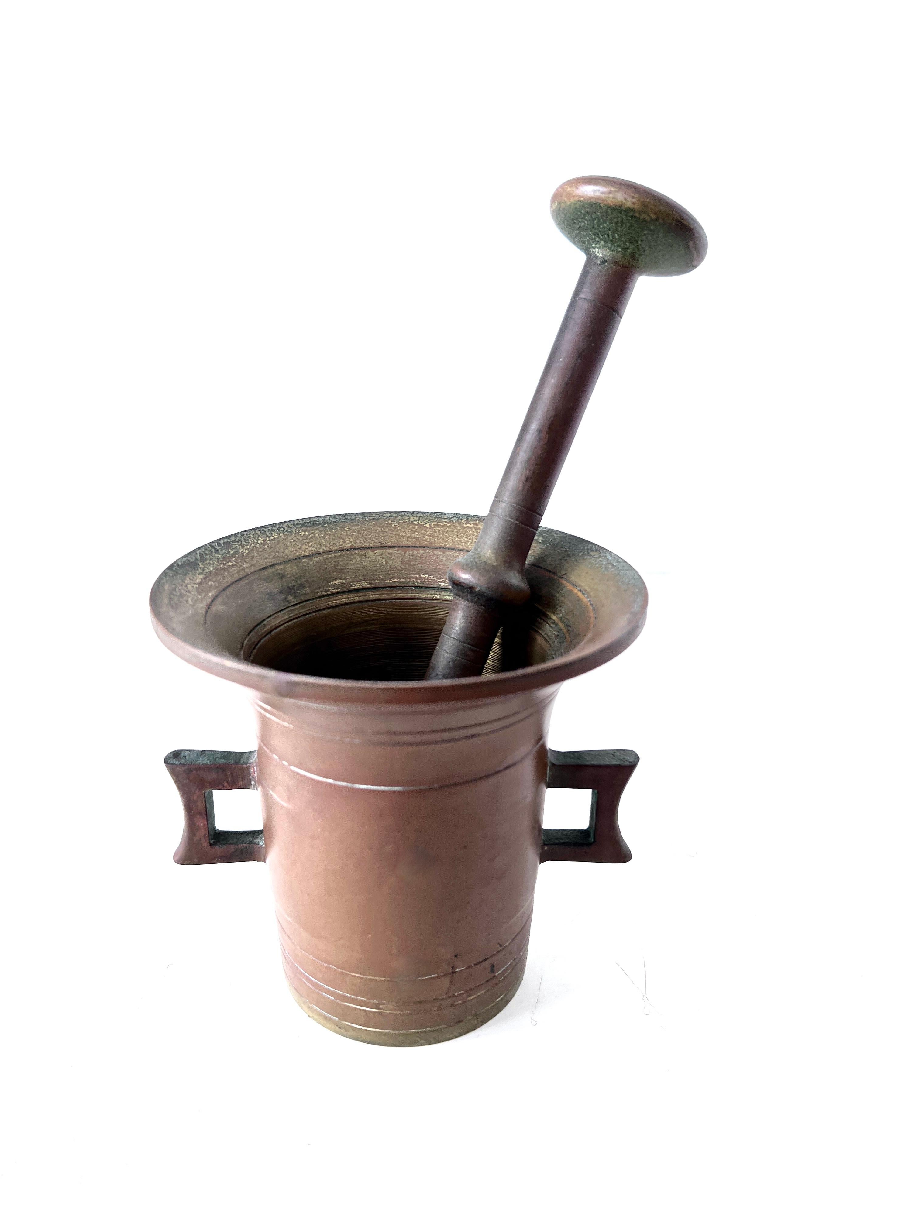 A vintage Mortar and Pestle of brass.  The piece is quite patinated, but could easily be brought to a full gleaming shine.

Mortars and pestles ahve been around for many years = to crush herbs and spices and also to work with patients who need