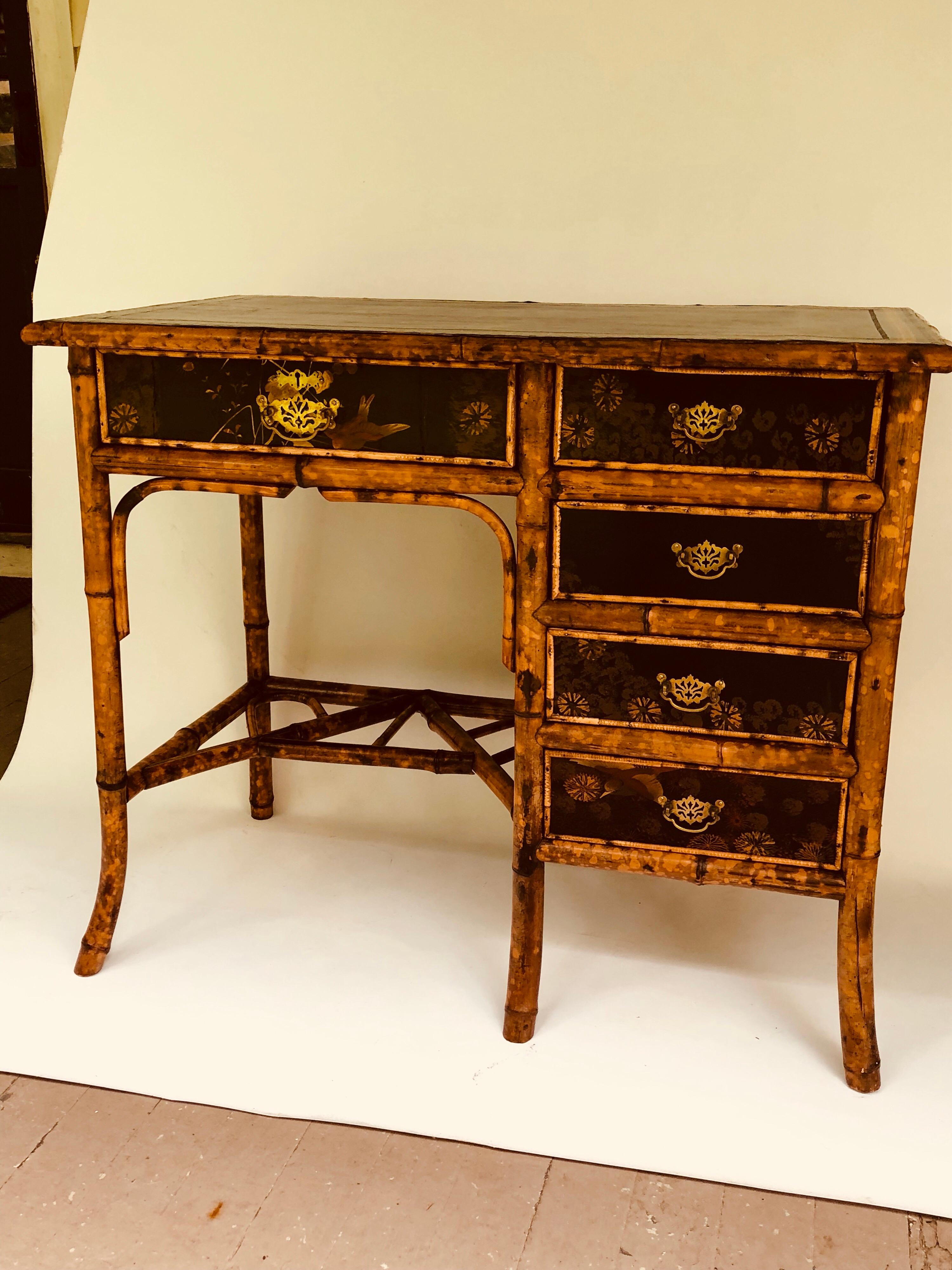 Decorative Victorian bamboo, lacquer and brass-mounted desk, with five (5) drawers. Inset leather top and lincrusta (Victorian wallpaper) applied paper on the right hand side. Probably a crack on that side, hidden by wallpaper application.