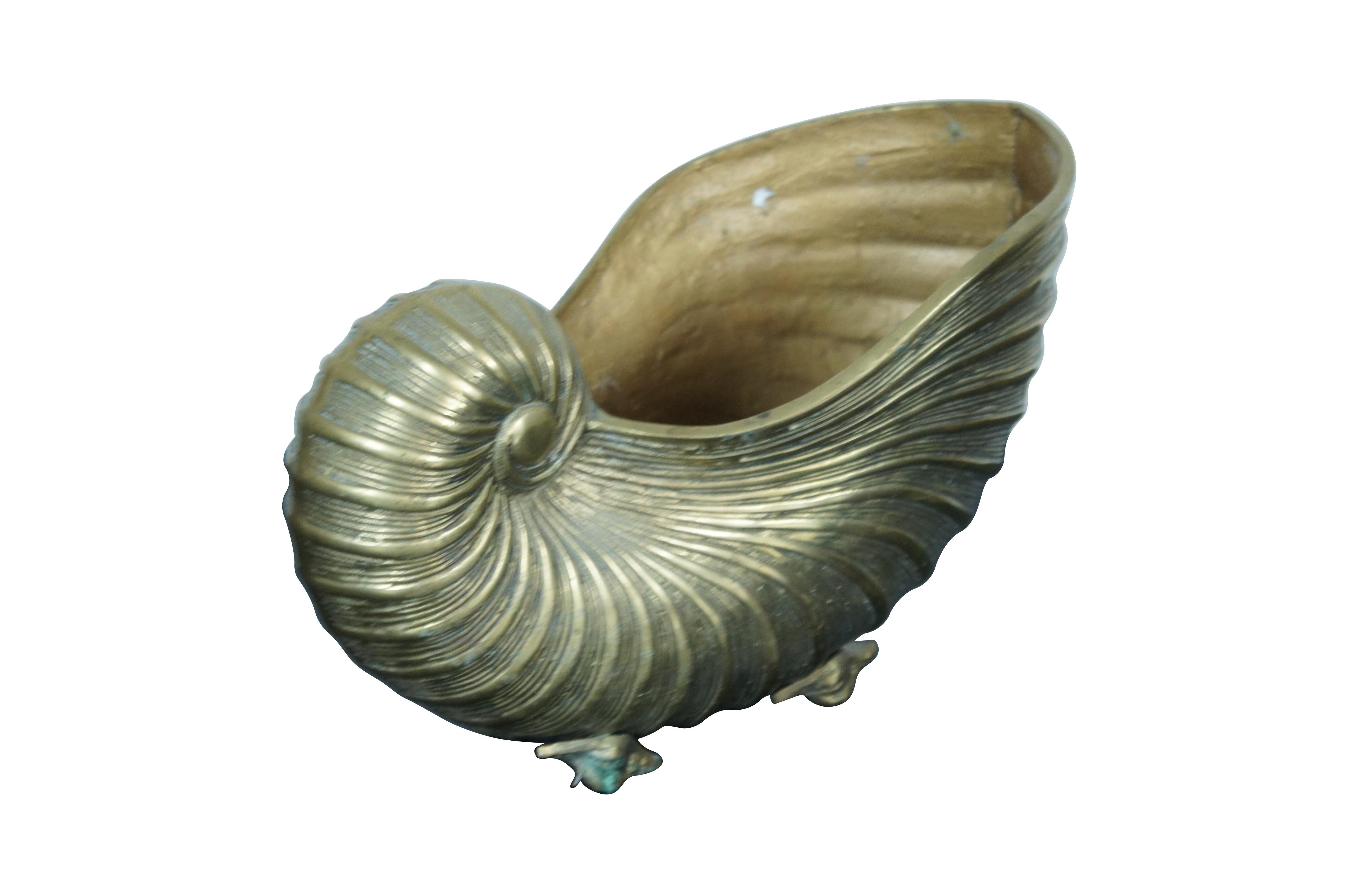 Une grande et impressionnante jardinière / jardiniere / catchpot en laiton massif du milieu du 20e siècle de la Régence hollywoodienne.  centre de table en forme de nautile / coquillage en spirale avec des pieds en coquille de conque.

Dimensions