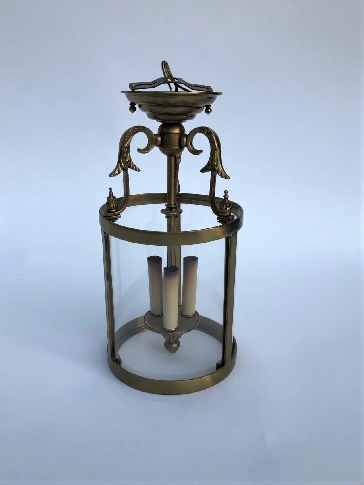 Elegant Brass Neoclassical Regency Lantern with 3 Candelabra Light Cluster and 3 Curved Glass Panels.

Five (5) Available - One (1) with Chip in Corner of One Glass Panel. Quoted Price Per Lantern.