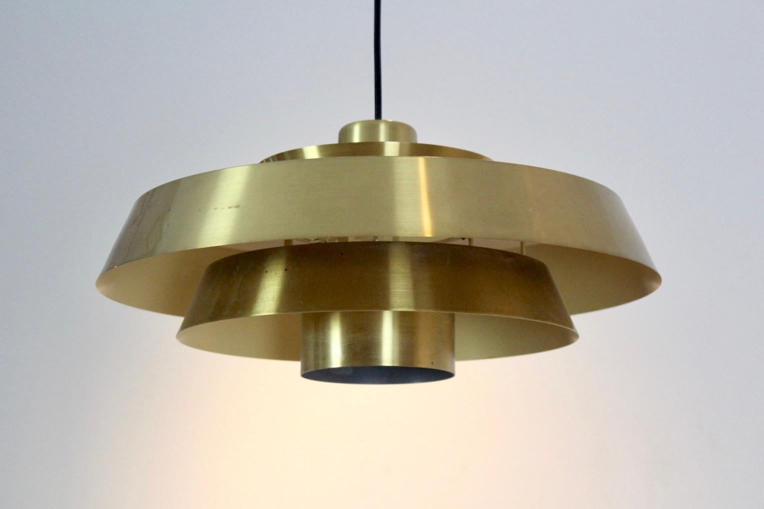 Mid century pendant light, model 'Nova', was designed by Jo Hammerborg in the 1960s and later manufactured by Fog & Morup in Denmark. It is made from massive Brass. This item remains in a good vintage condition with some minor wear on the upper