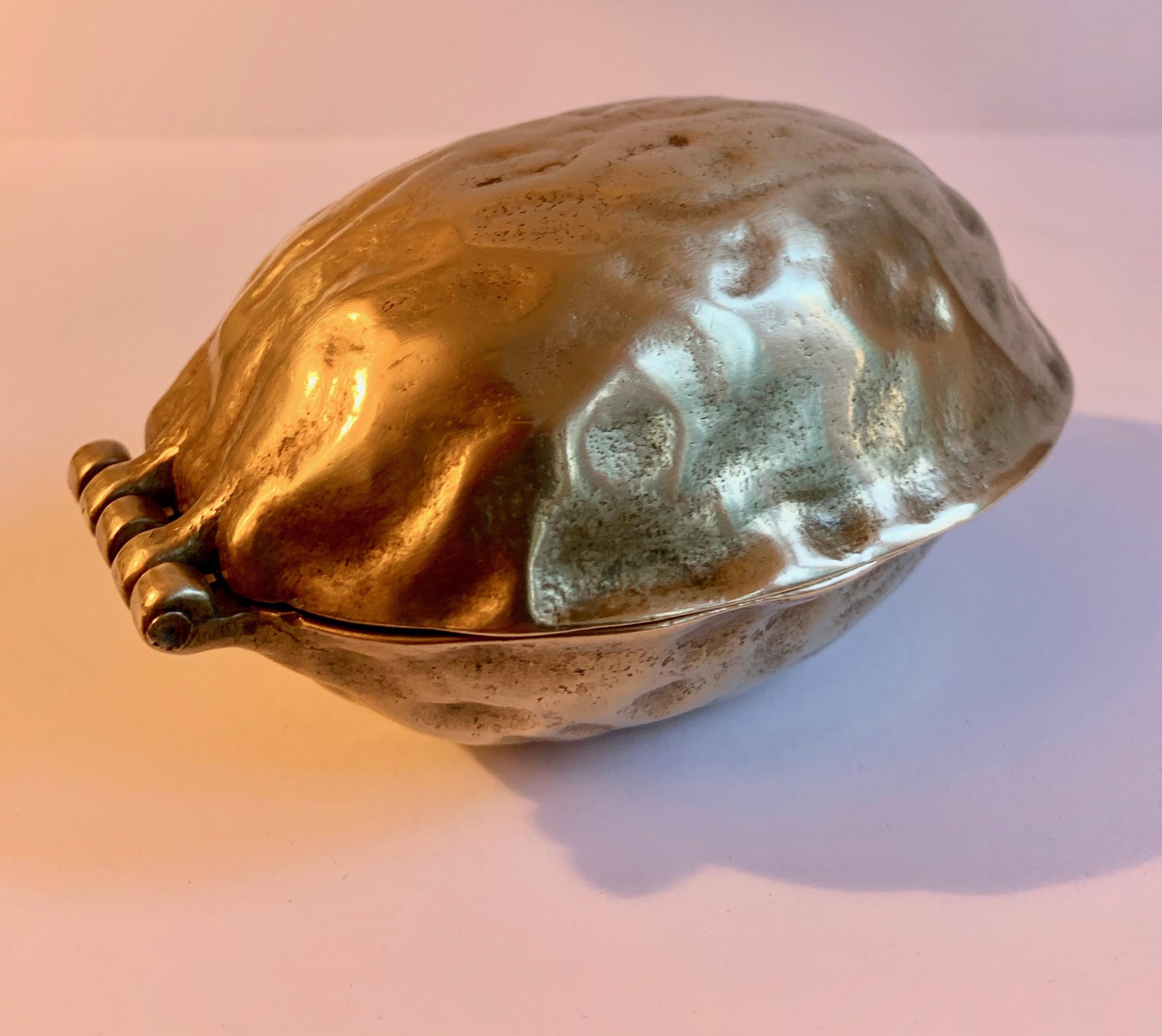 Brass nut cracker in the shape of a walnut. Great or cracking walnuts. Hazel nuts are shown for example, however not the best cracker for small nuts... a nice decorative piece... lovely alone or for practical use. Holiday, decor, nut crackers brass.