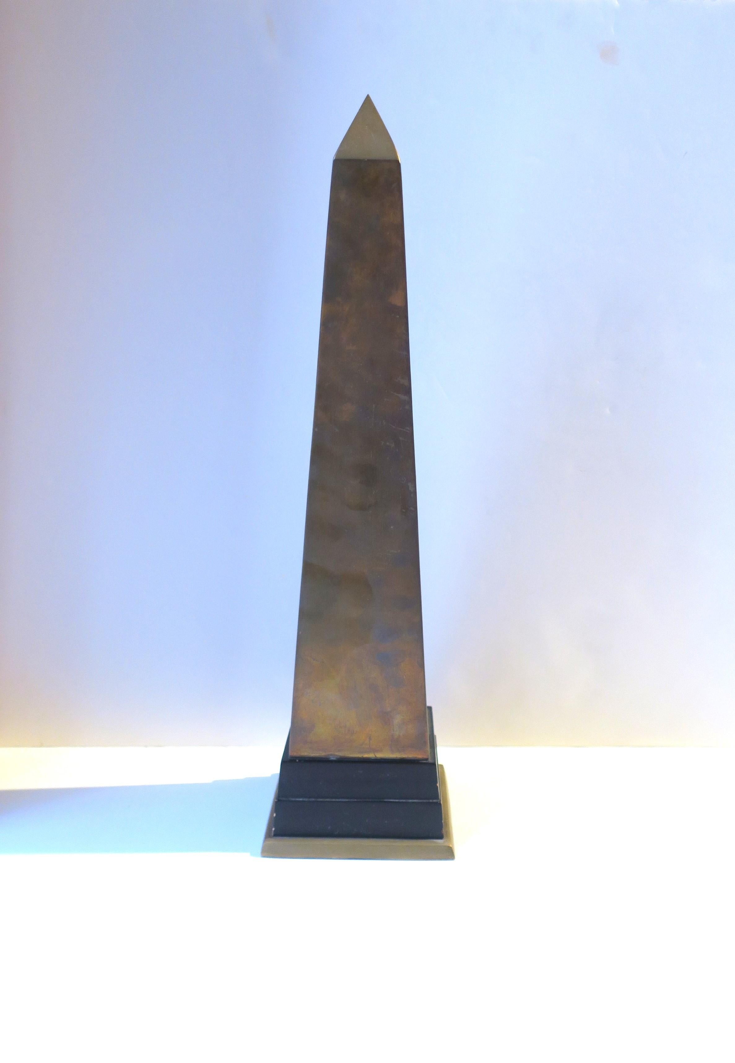 A single brass and wood Obelisk, in the Modern style, circa late-20th century. A great decorative object, statement piece on a mantel, sideboard, cocktail table, etc. Brass is shown unpolished (with patina.) Piece is a nice height. Dimensions: 20.5