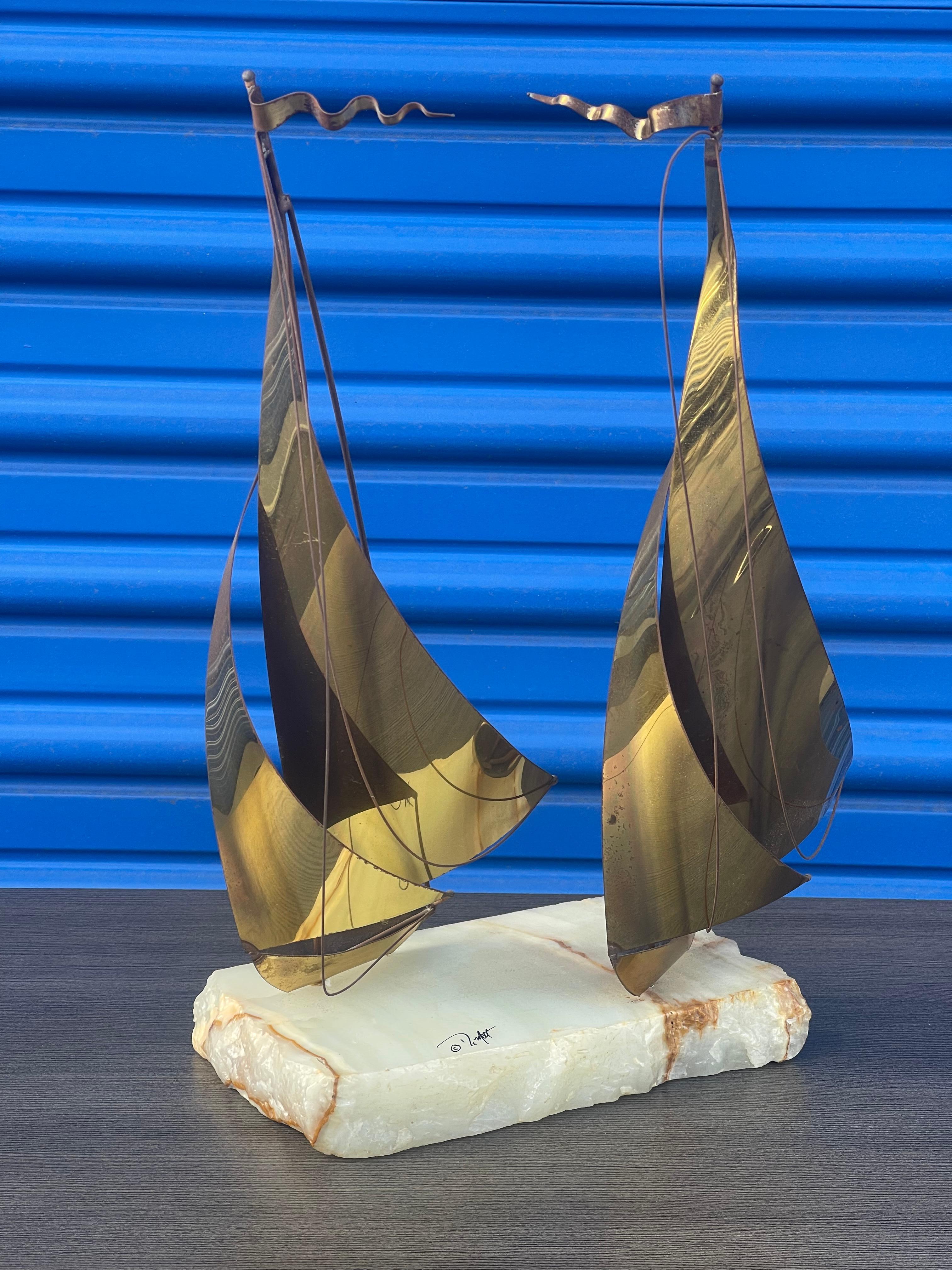 A really nice looking brass on quartz base dual sailboat sculpture by DeMoot, circa 1970s. The sculpture is in good vintage condition with a nice patina and measures 12